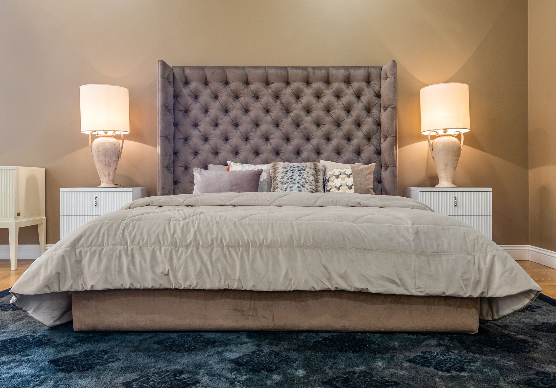 An upholstered bed in a neutral bedroom