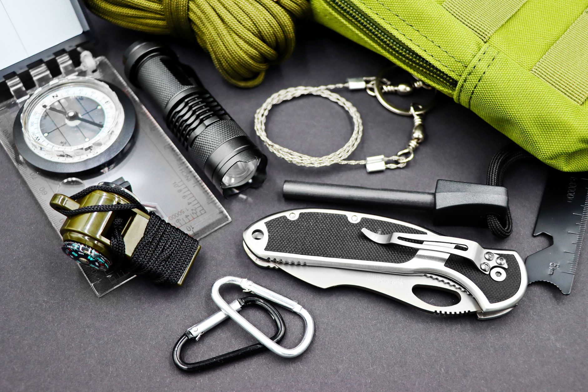 A flashlight, compass and survival tools laid out