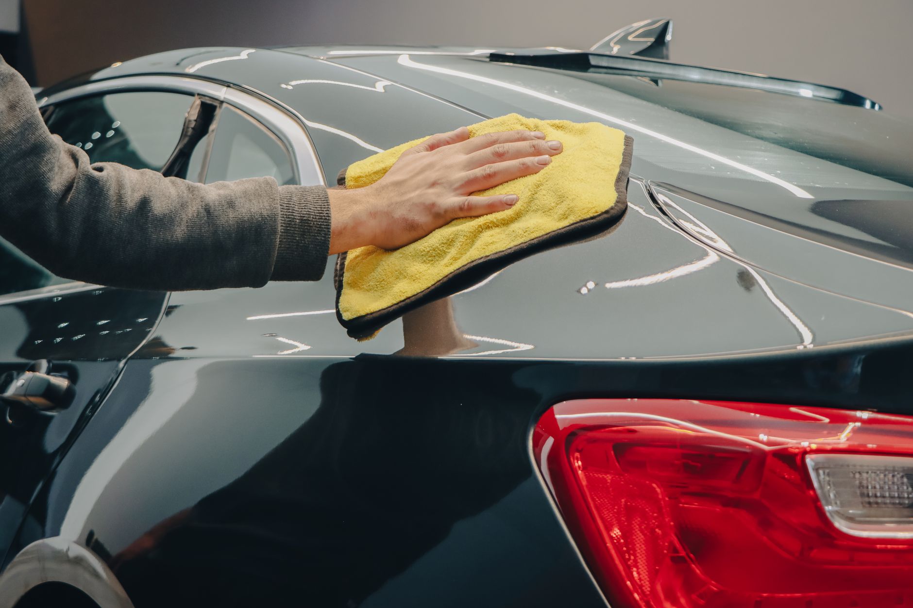 Polishing part of a car by hand with a cloth