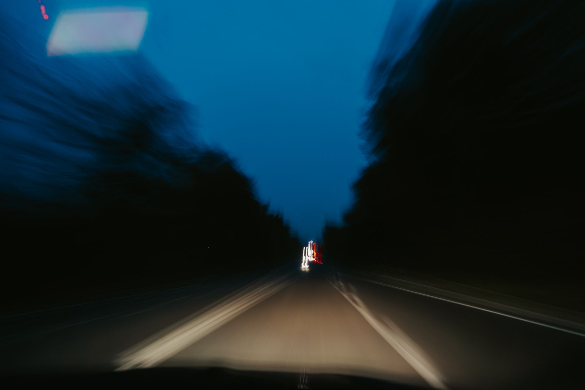 A dark road seen from a moving car at night