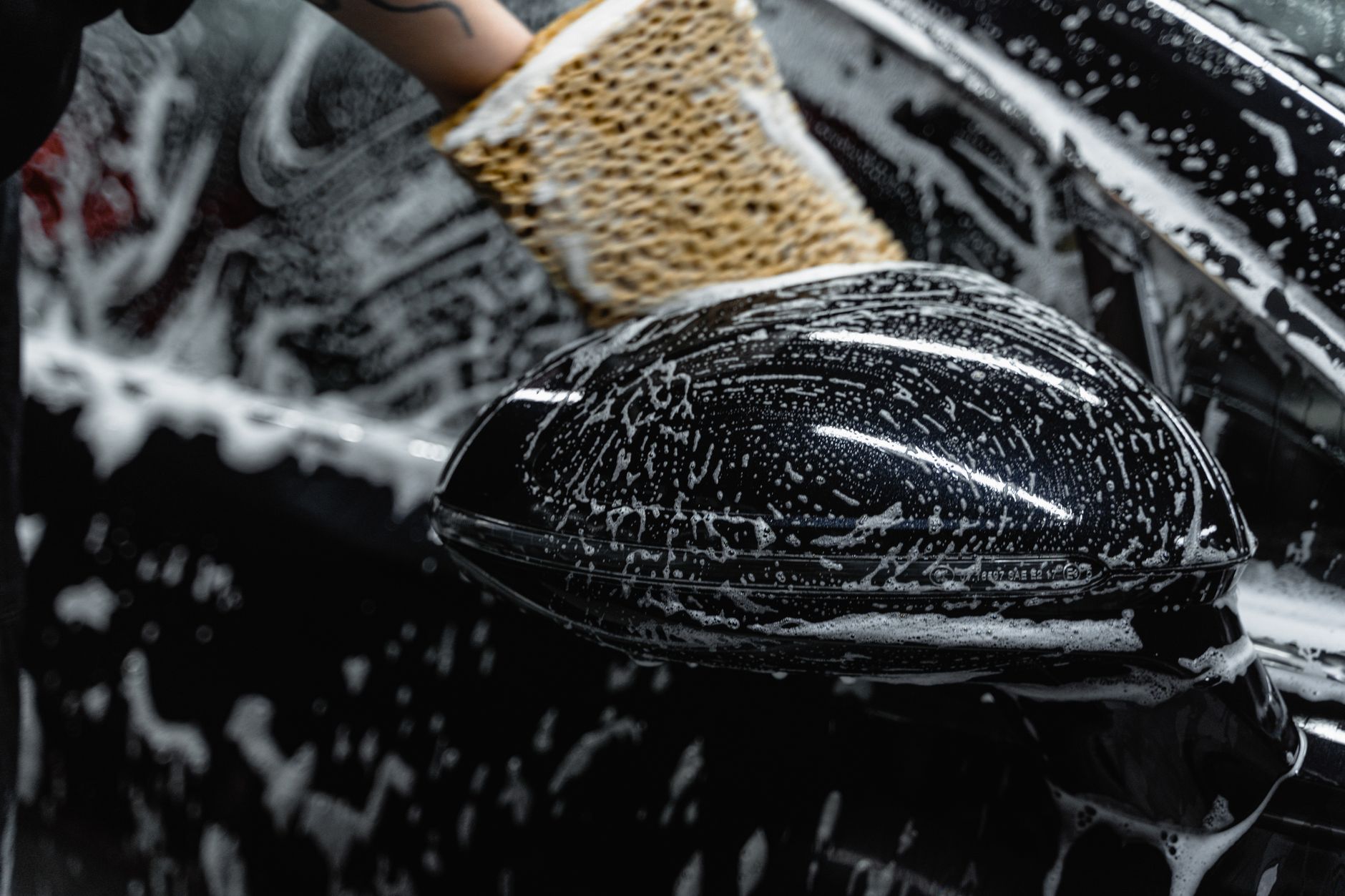 Washing a car with a soapy sponge