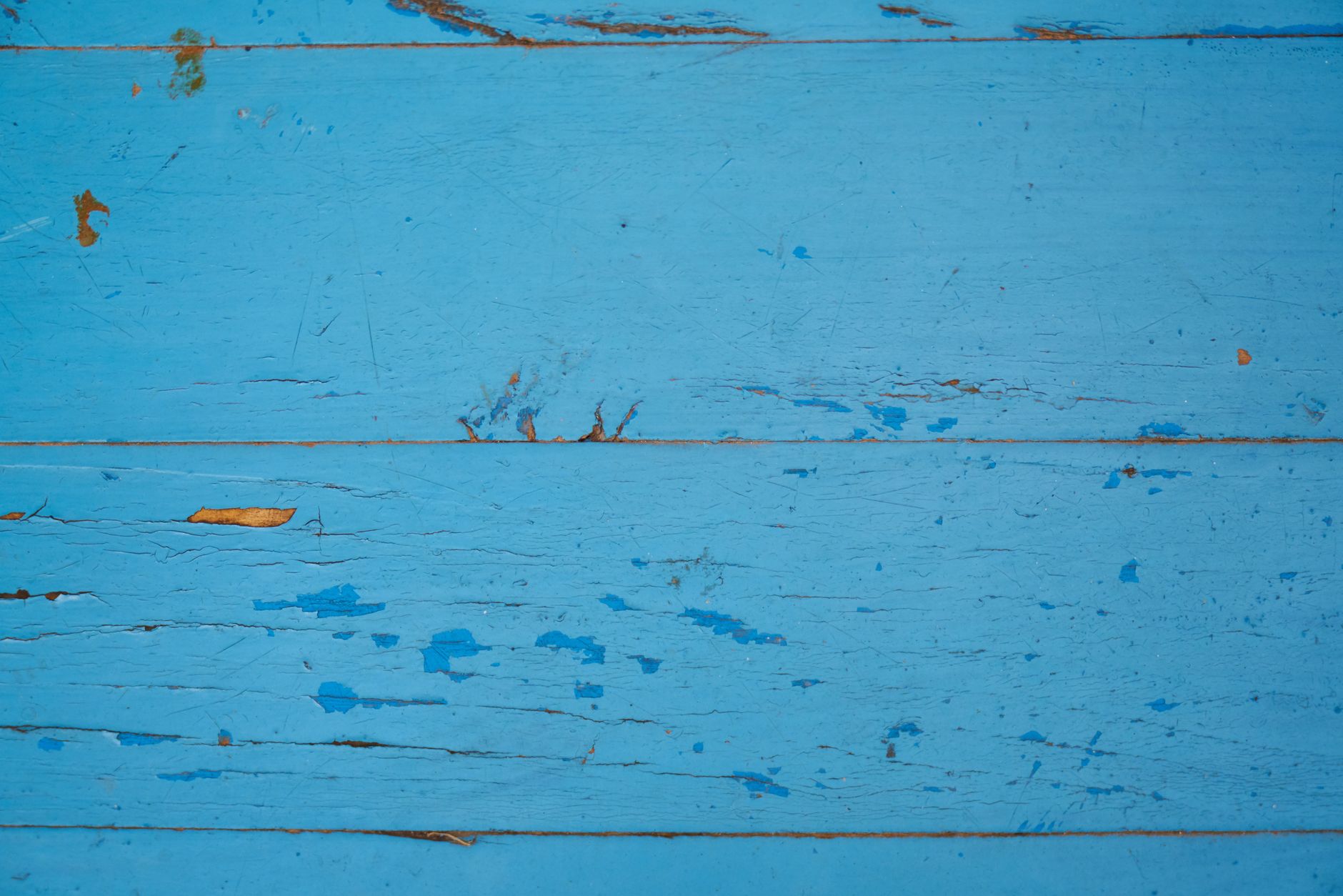 Peeling blue paint on wooden boards