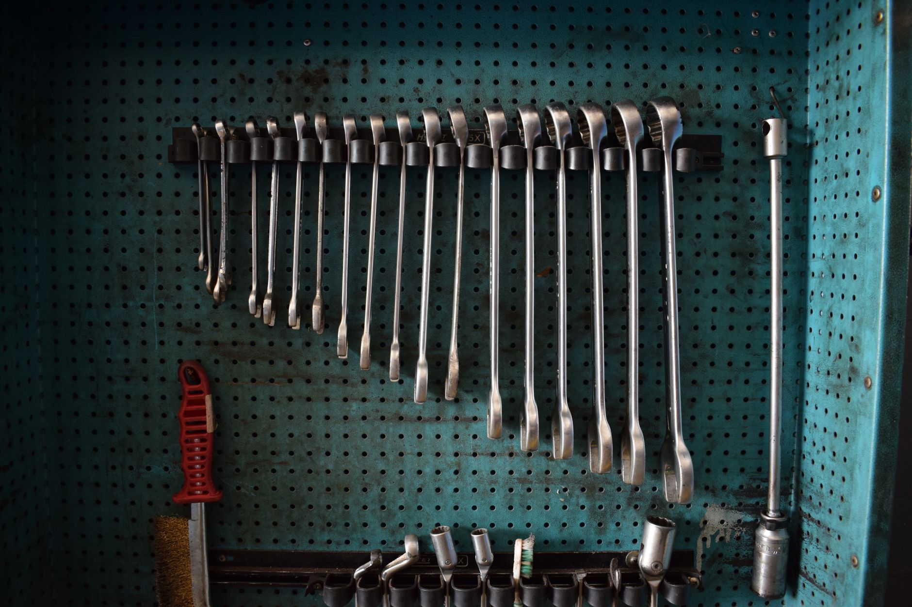 Wrenches hanging on a workshop pegboard