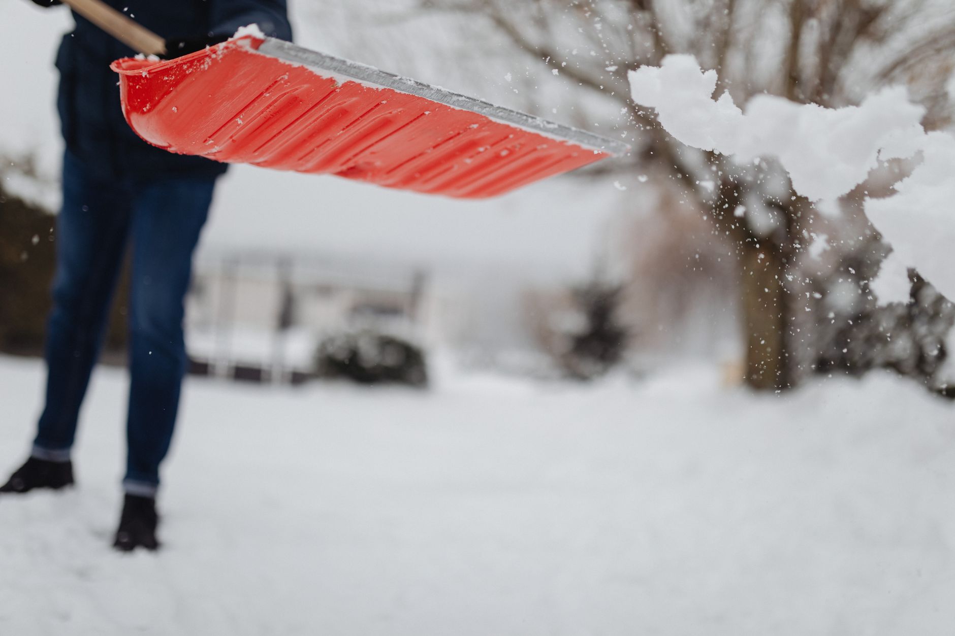 Someone clearing snow outside a house