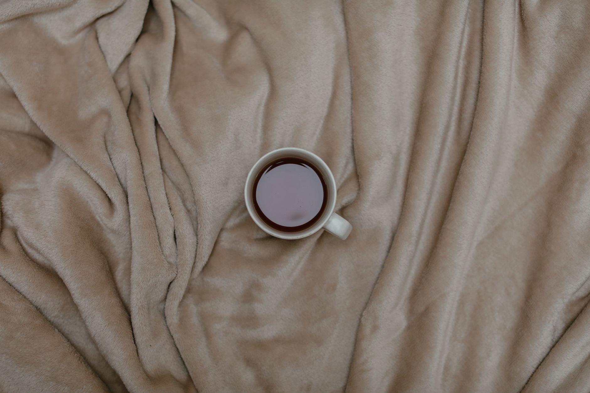 A warm mug resting on a soft blanket