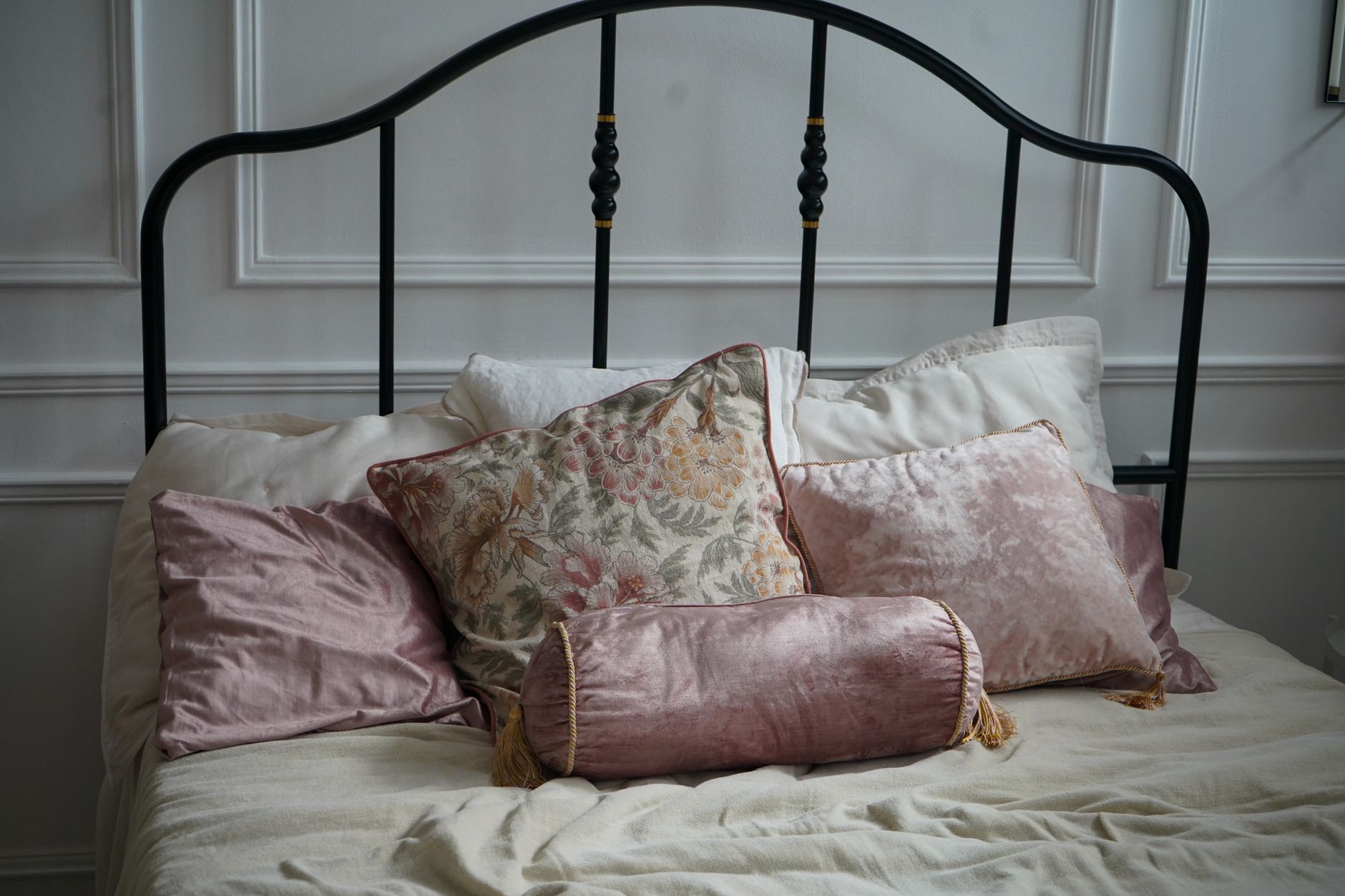 A made bed with pillows in a quiet bedroom
