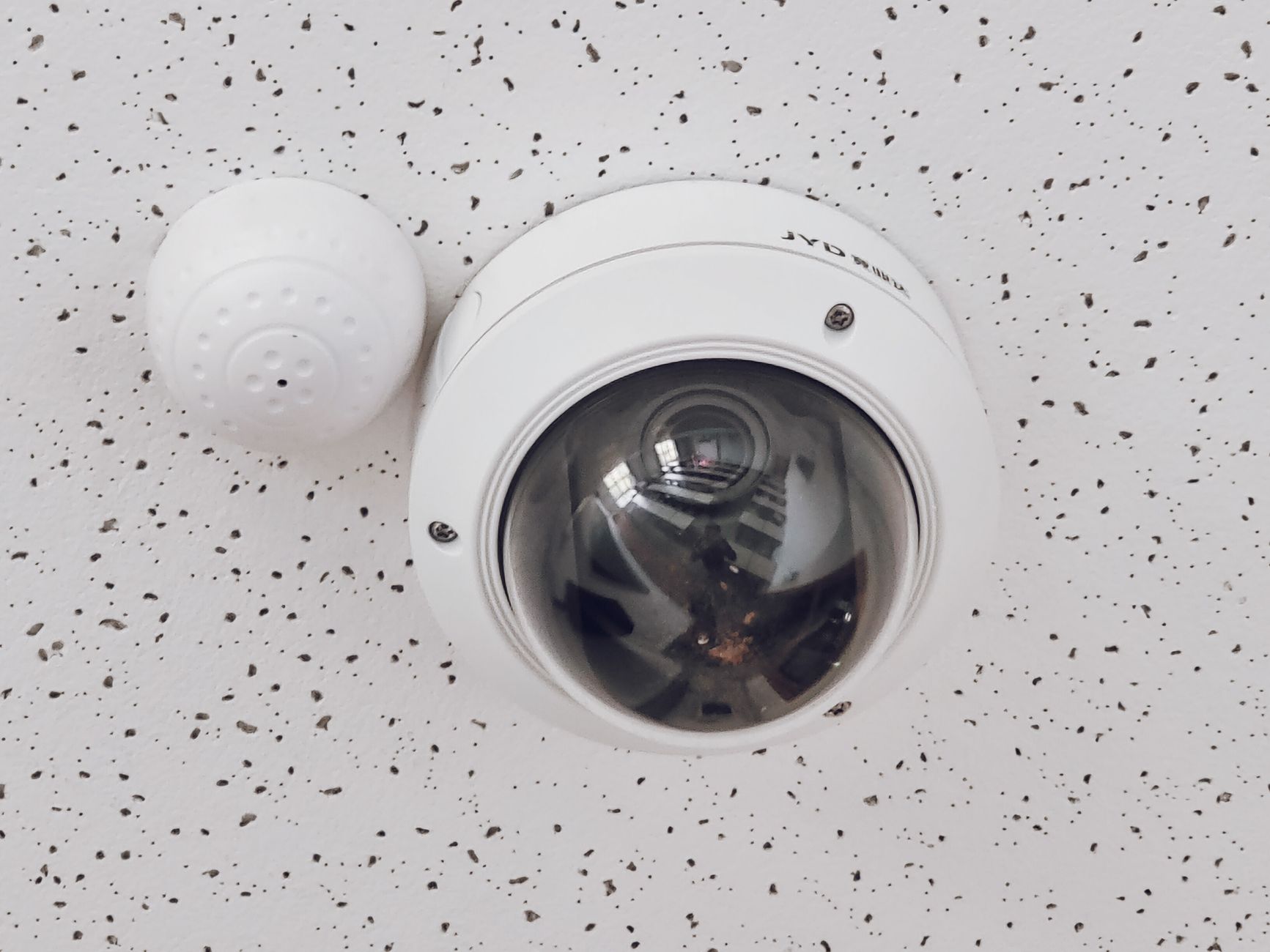 A smoke detector beside a ceiling camera