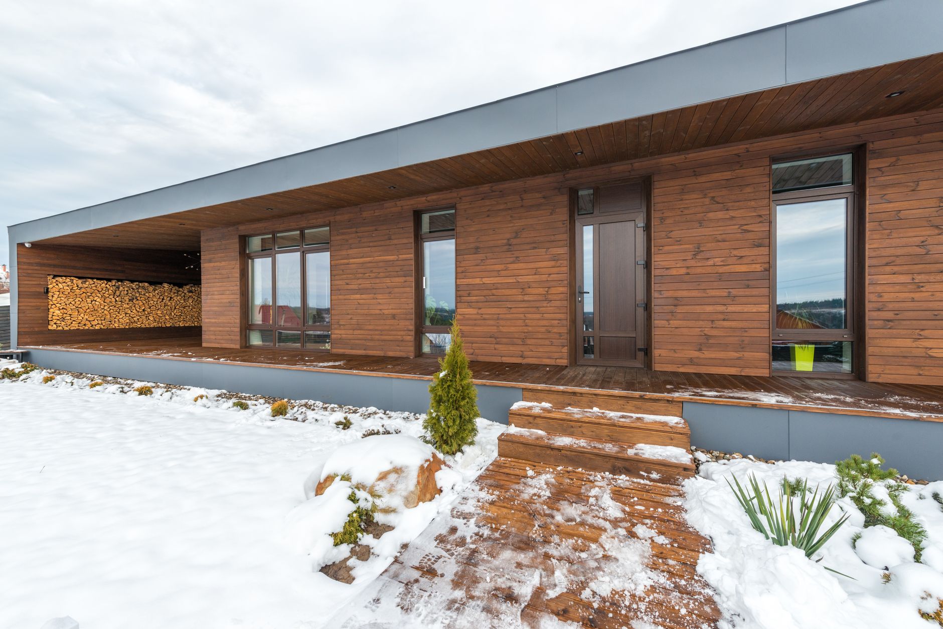 A modern house with a snowy front walk