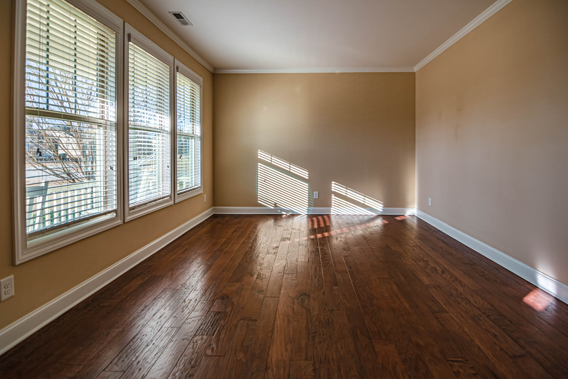 An empty room with sunlight through the blinds