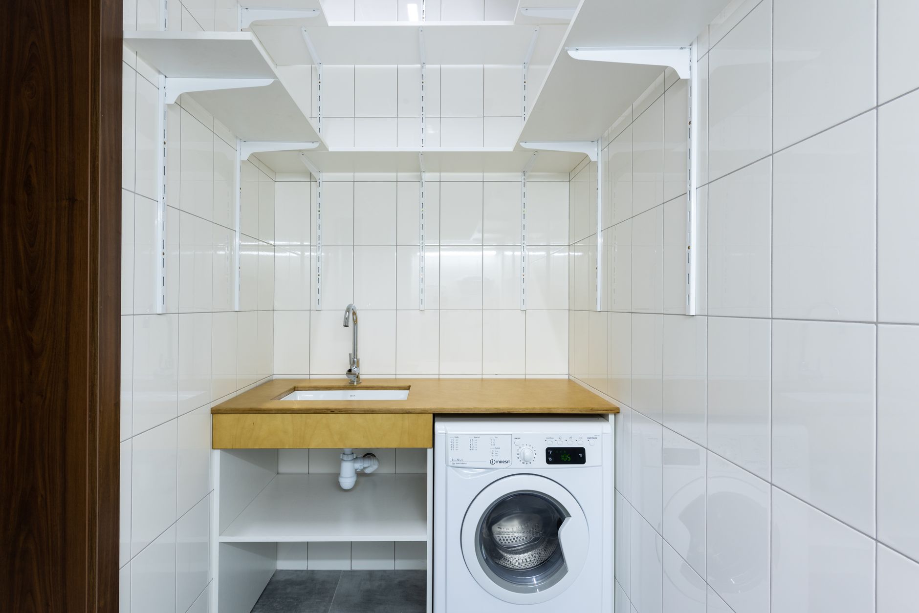 A small laundry nook with a washer and sink