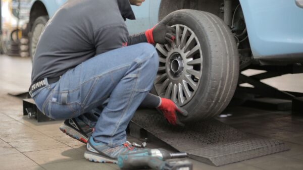 Best jack stands: a mechanic removing a wheel from a lifted car