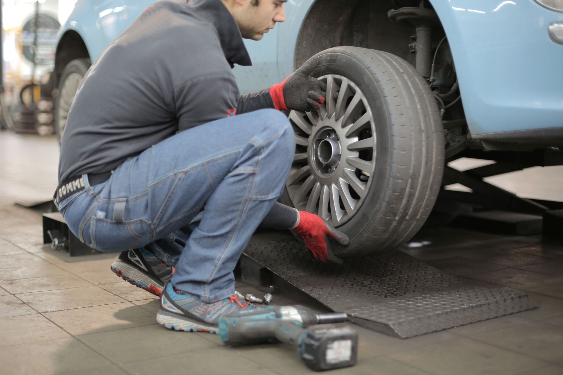 Best jack stands: a mechanic removing a wheel from a lifted car