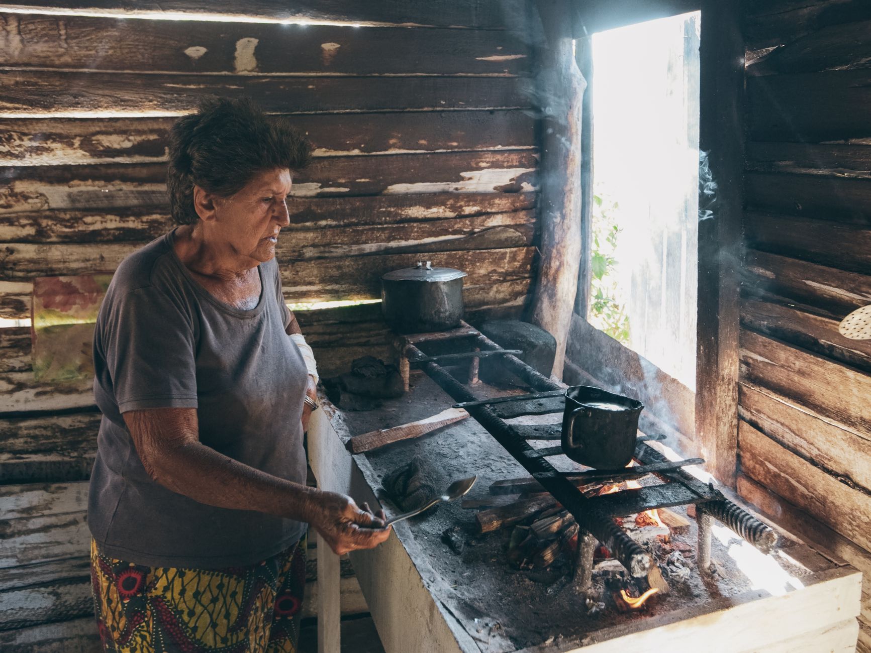 Best jar opener: an older woman cooking on a wood stove