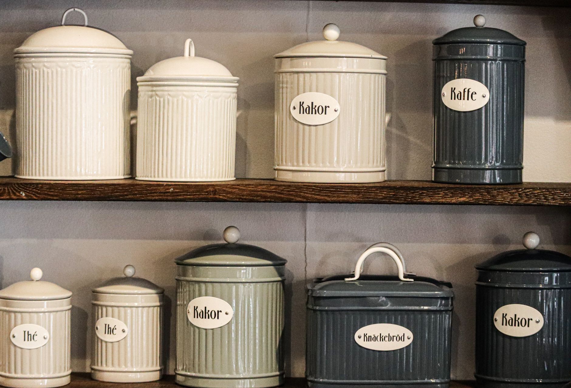 Labeled storage canisters on kitchen shelves