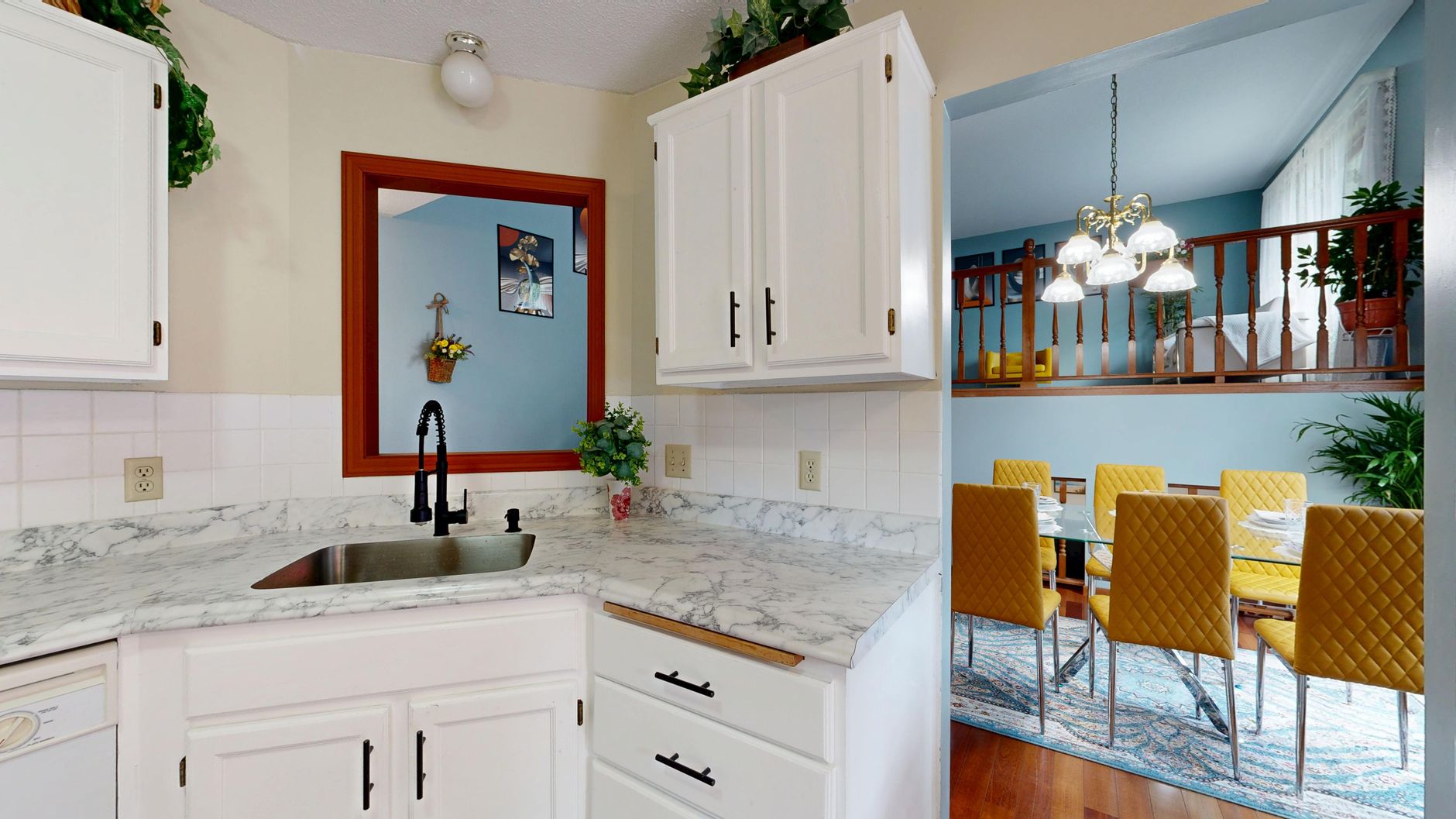 A kitchen sink with white cabinets