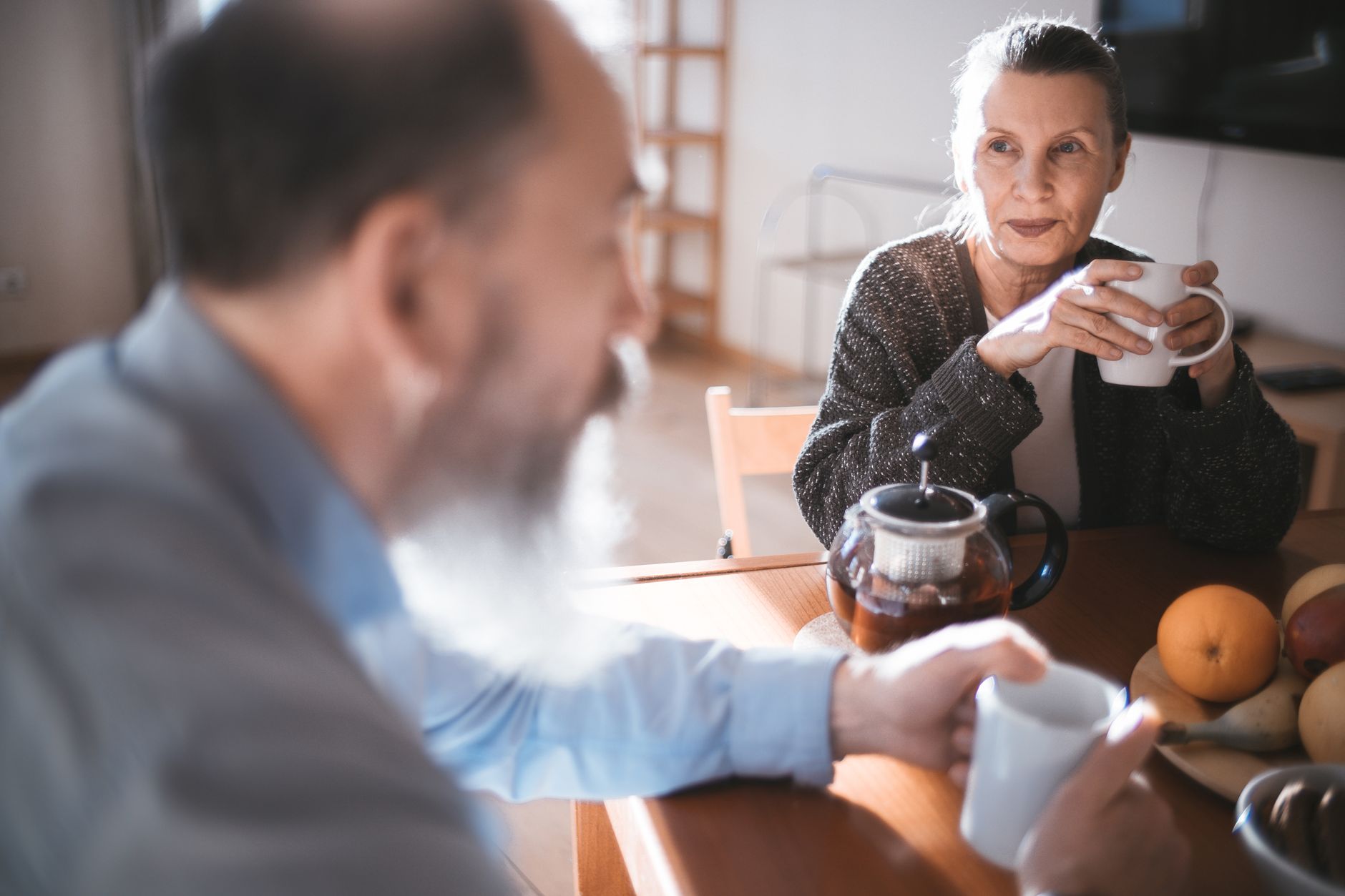 An older couple having tea at a kitchen table