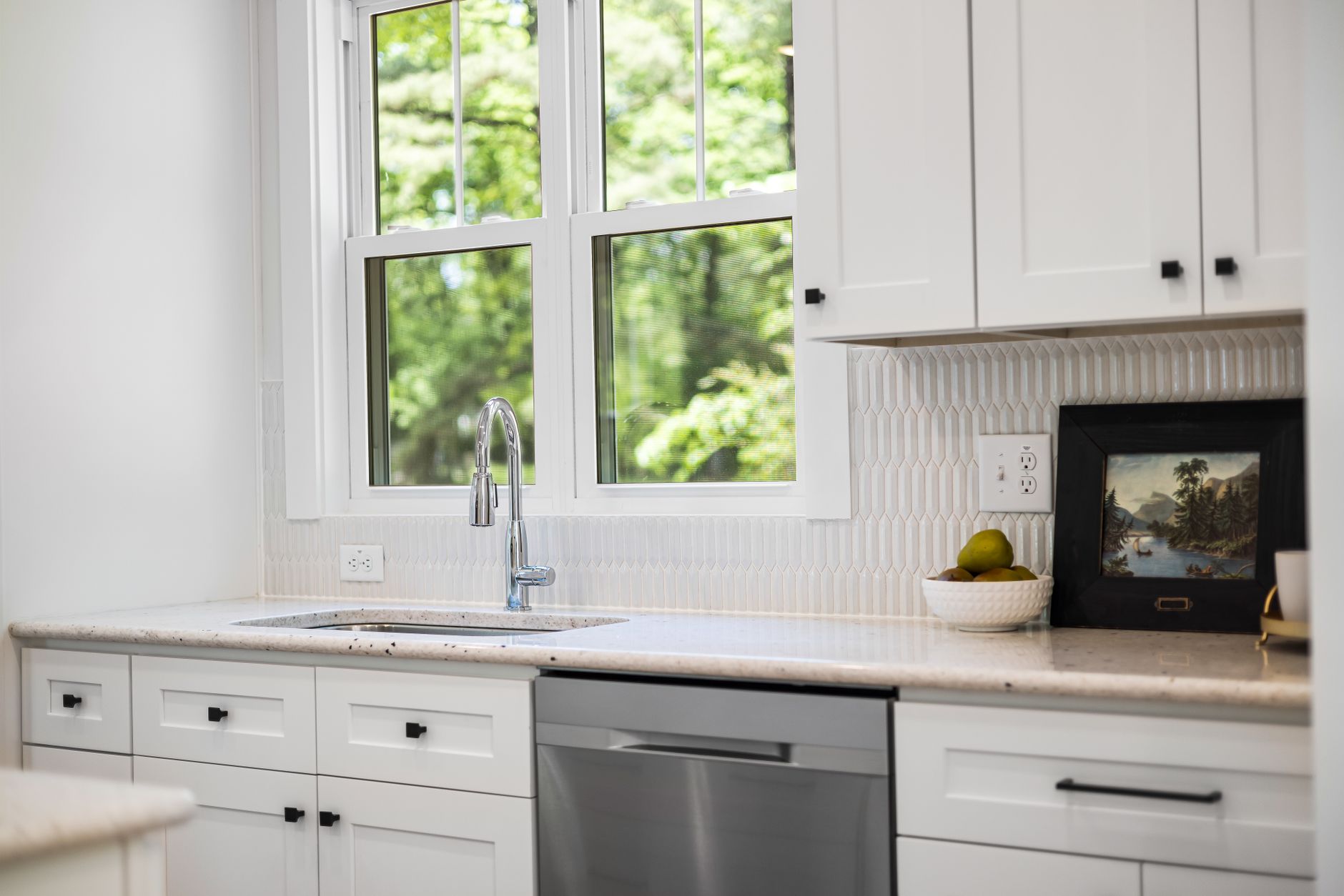 A bright kitchen with a sink under a window