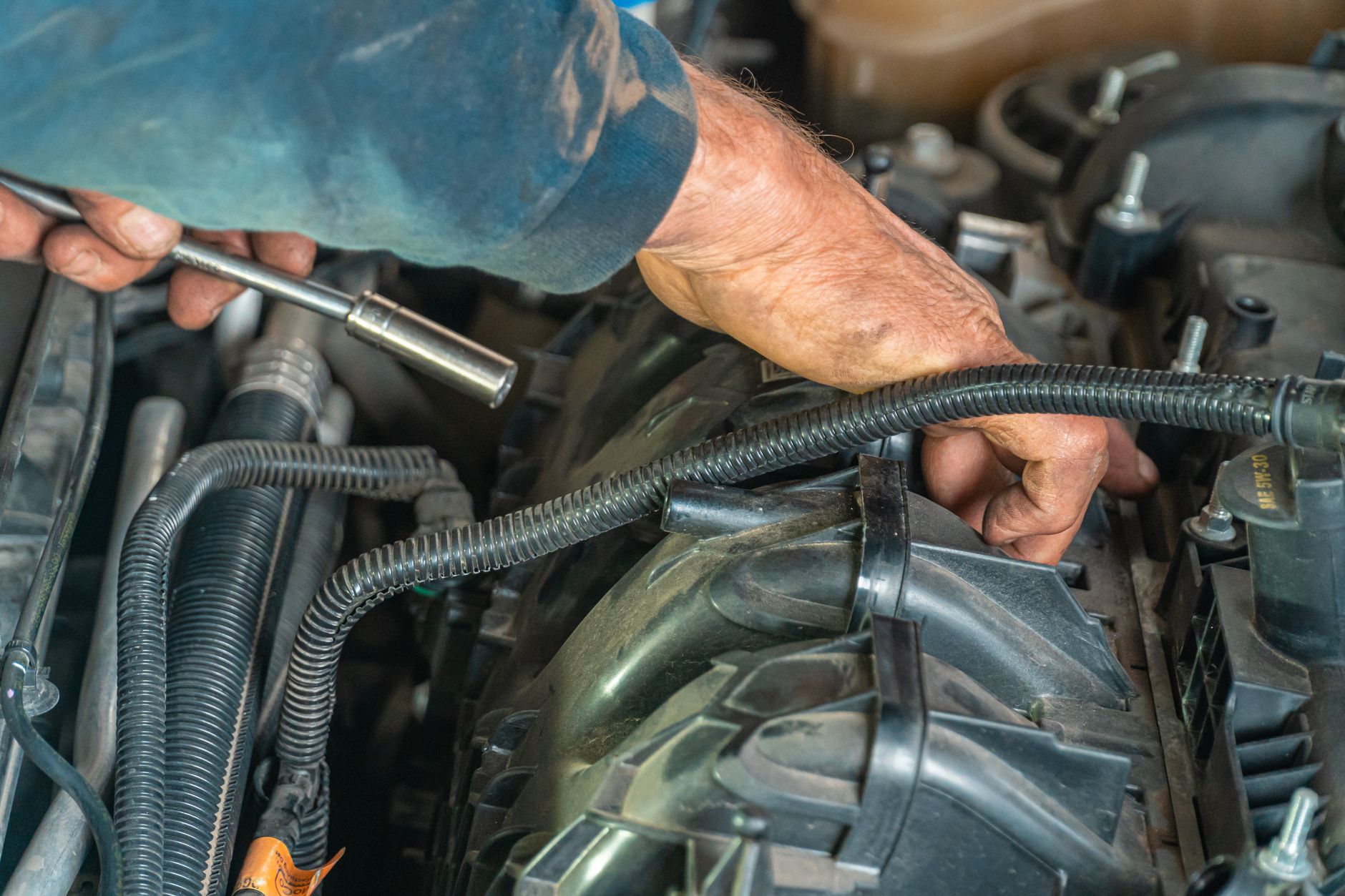 A person checking under the hood of a car