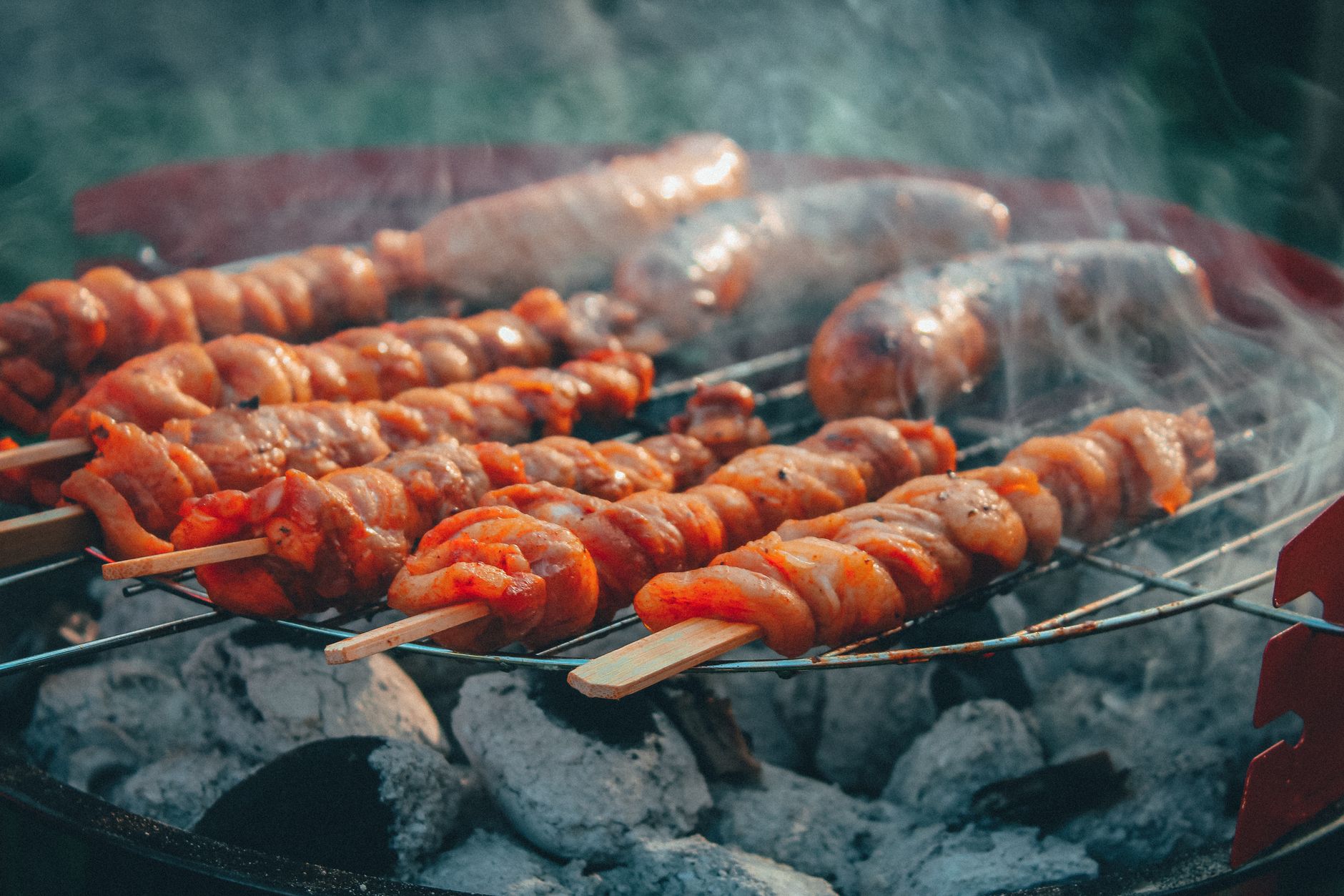 Skewers and sausages over charcoal