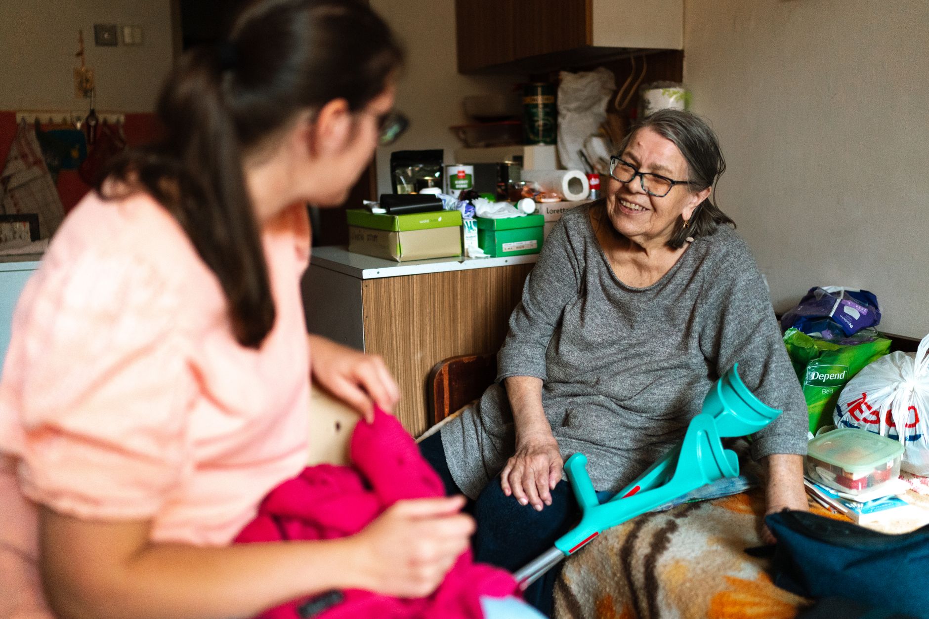 A young woman visiting an older woman at home