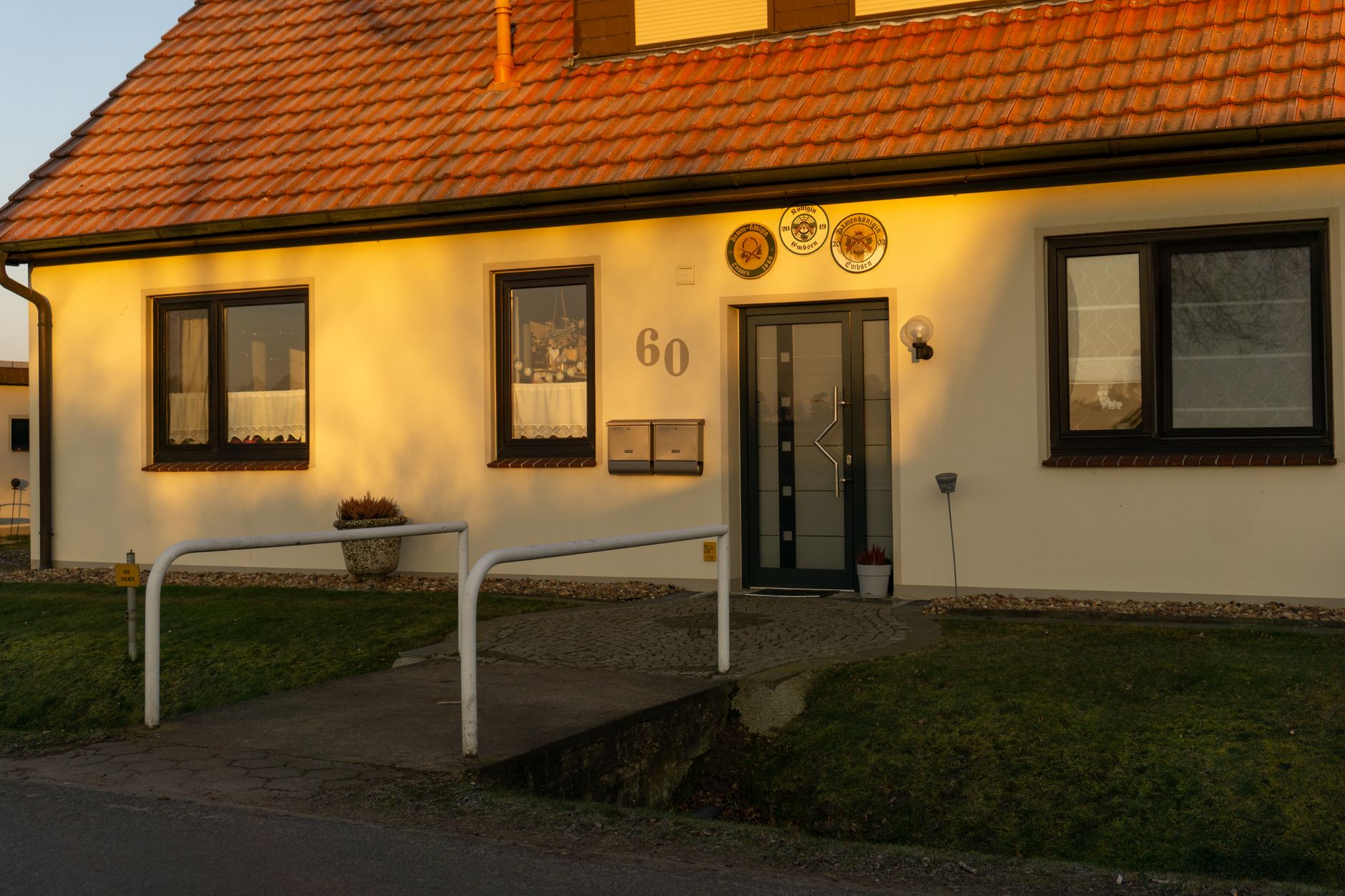 A house entrance with a handrail at sunset