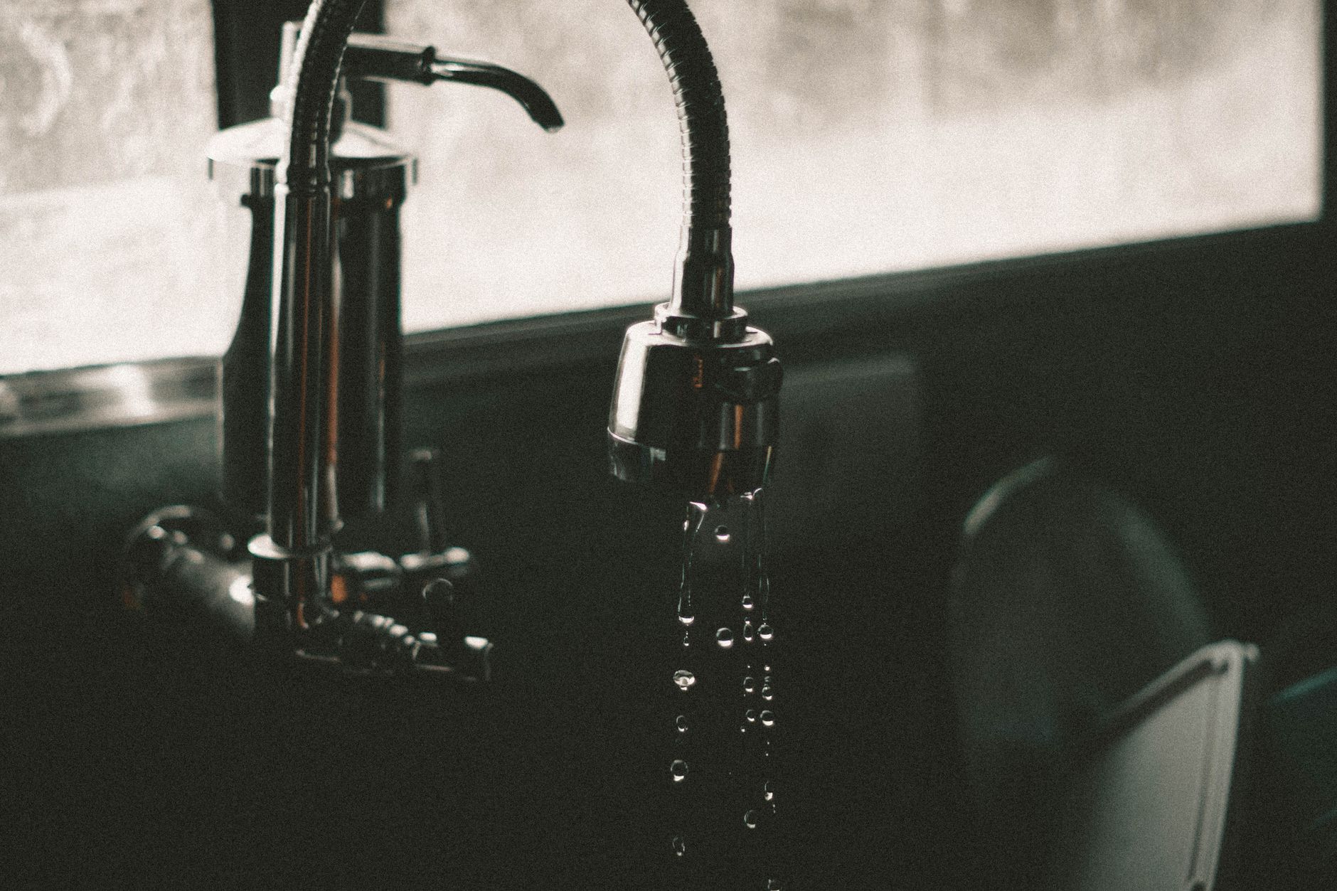 Water running from a kitchen faucet into a sink
