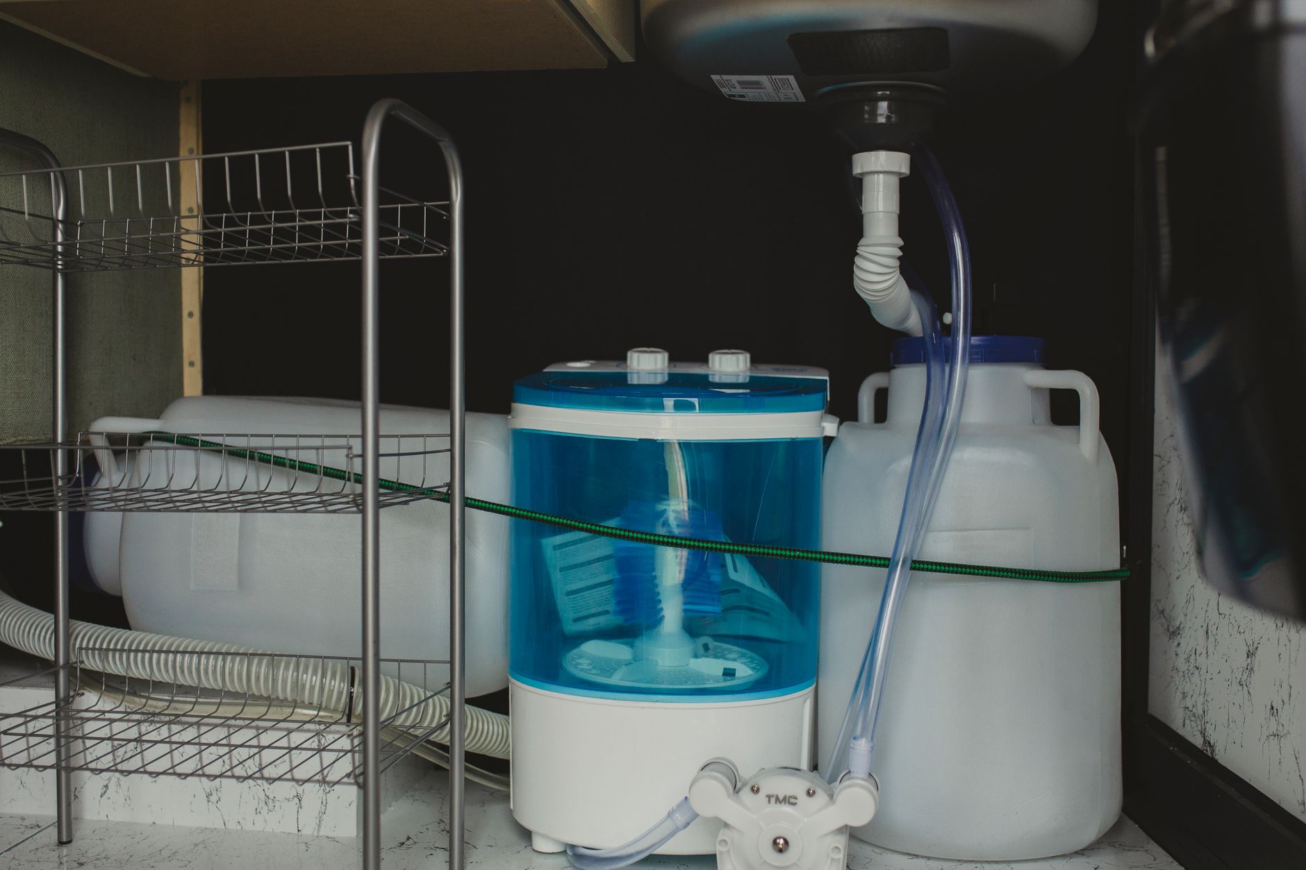 Plumbing and a water filter under a sink