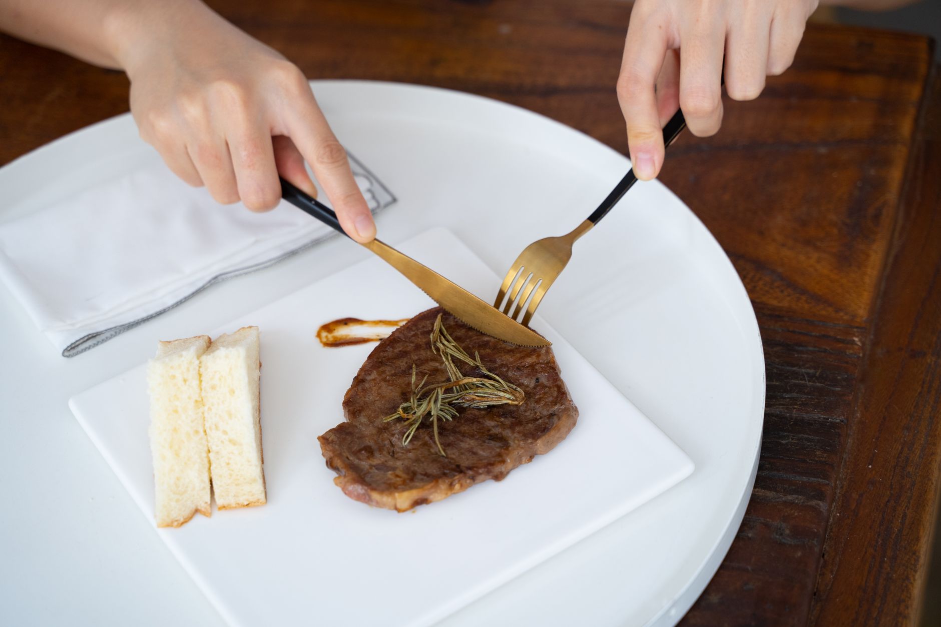 Cutting a steak with a knife and fork