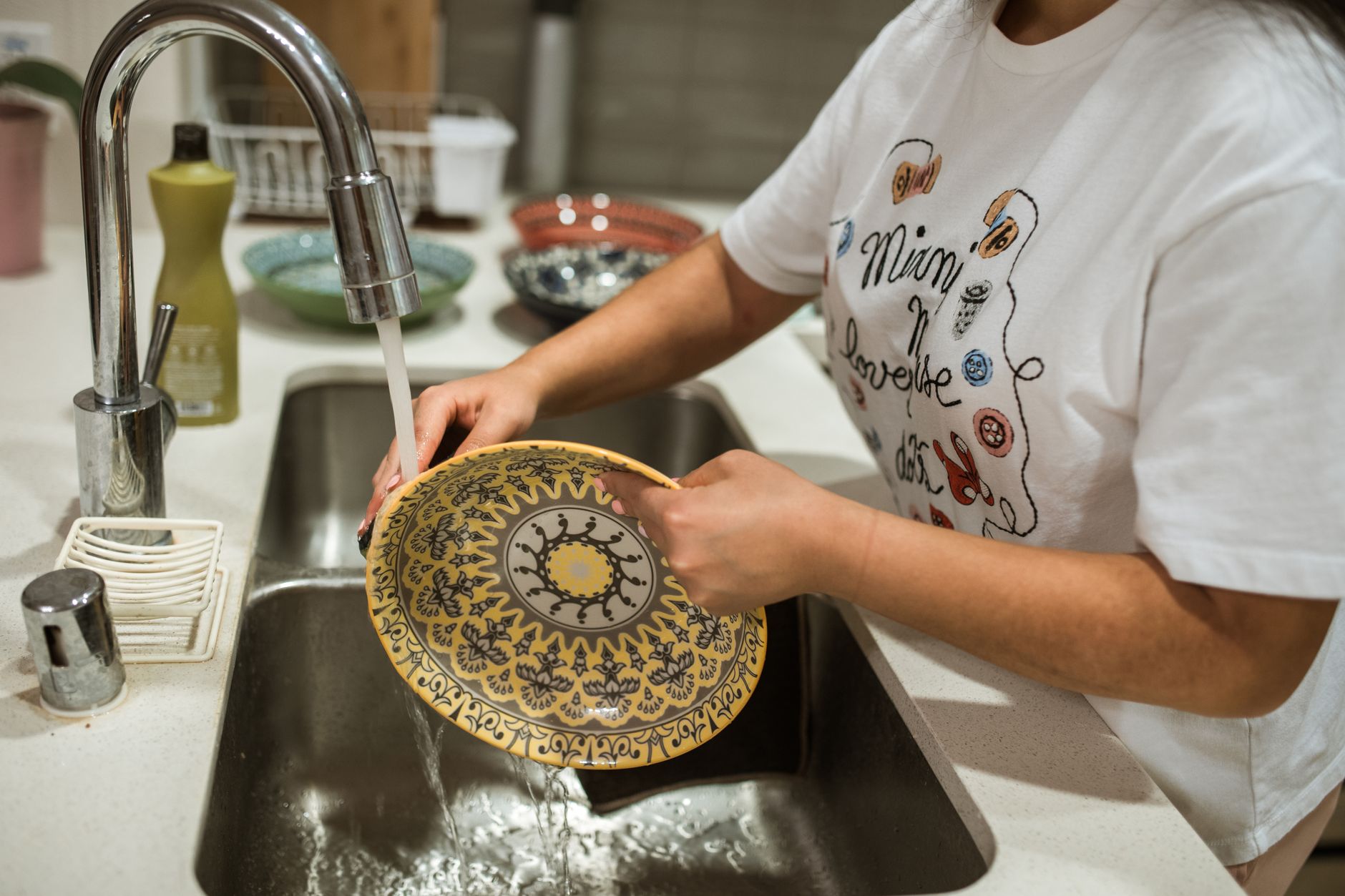 Washing a plate in a kitchen sink