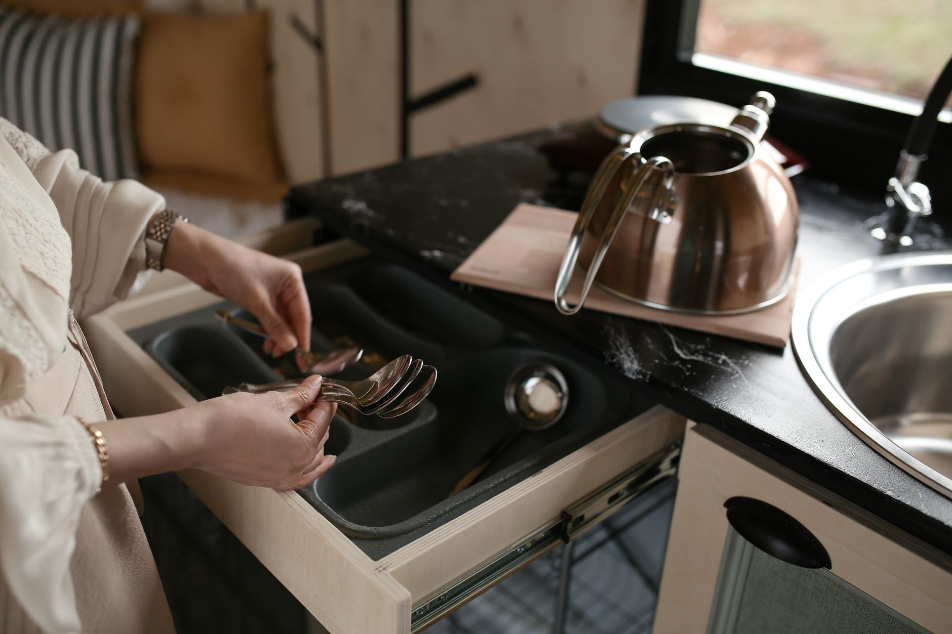 Putting spoons in a kitchen drawer organizer
