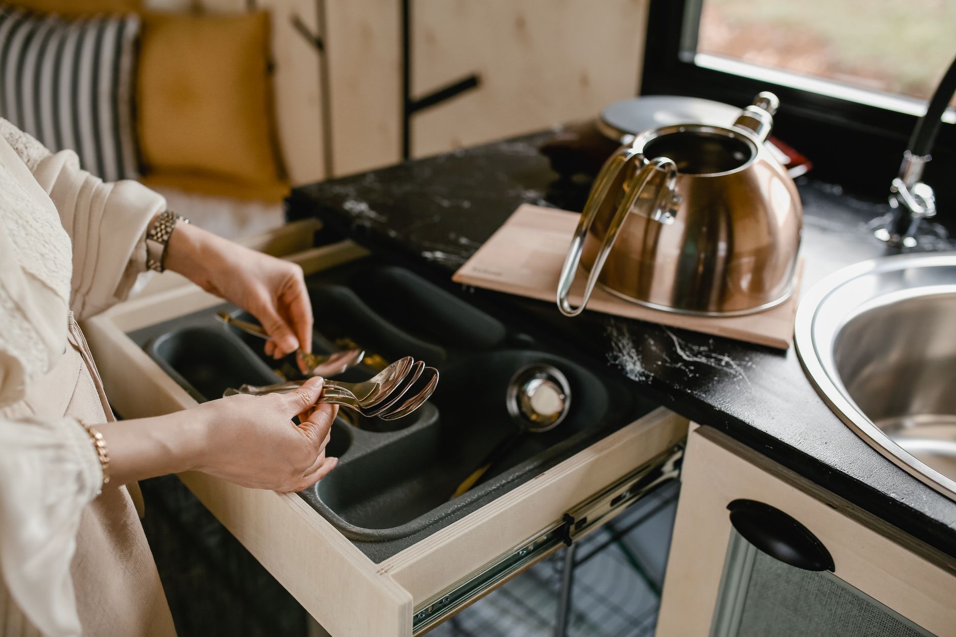 Putting spoons in a kitchen drawer organizer