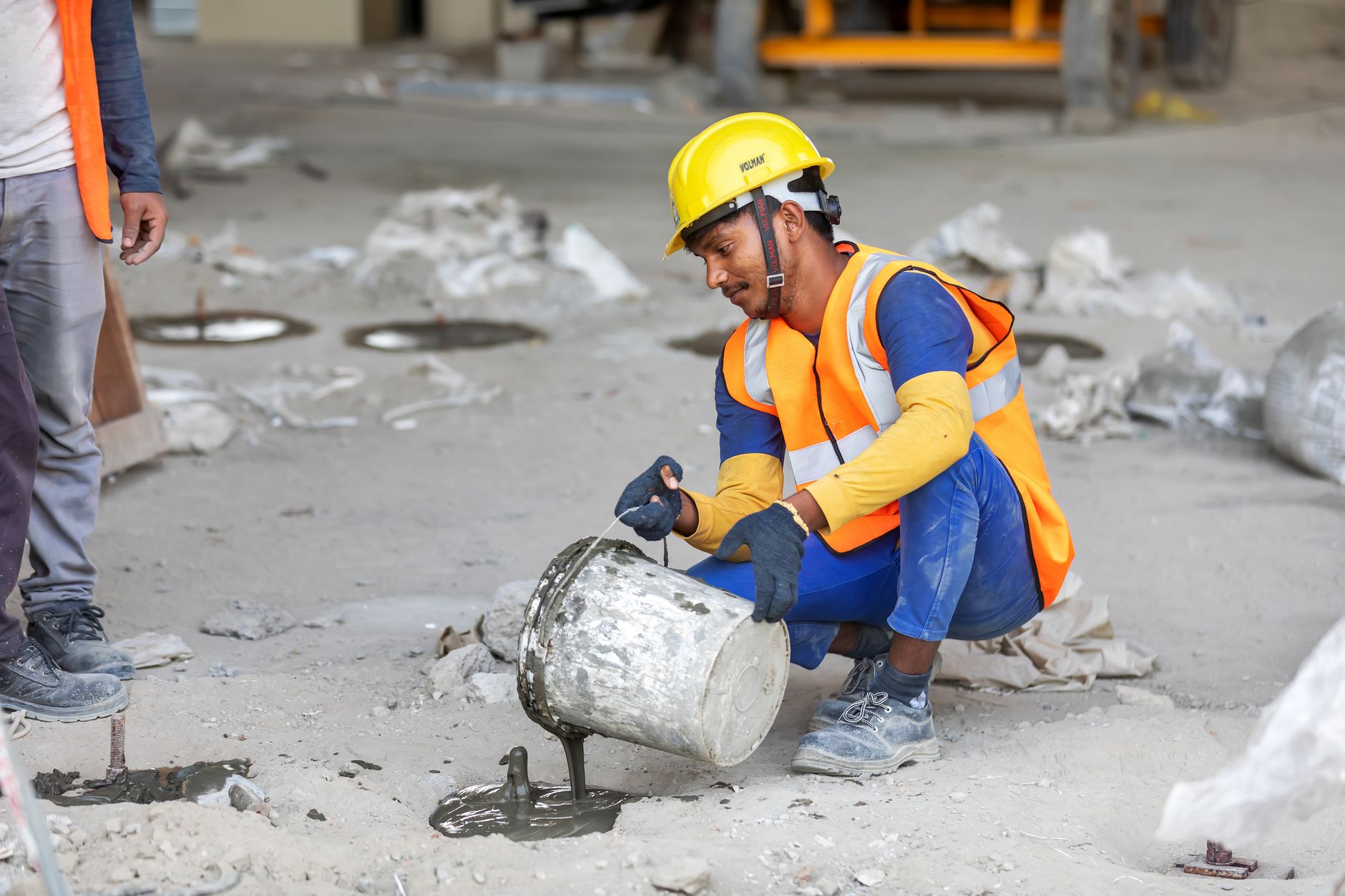 A worker crouching on a job site