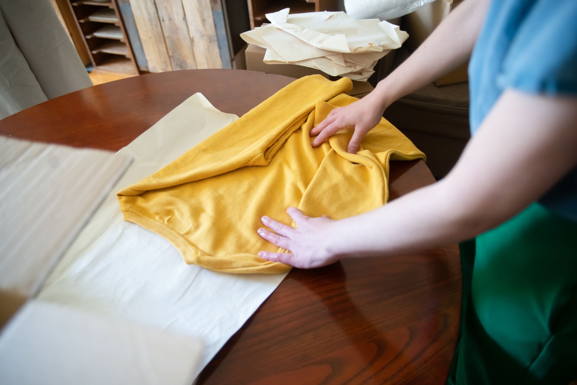 Folding a yellow shirt on a table