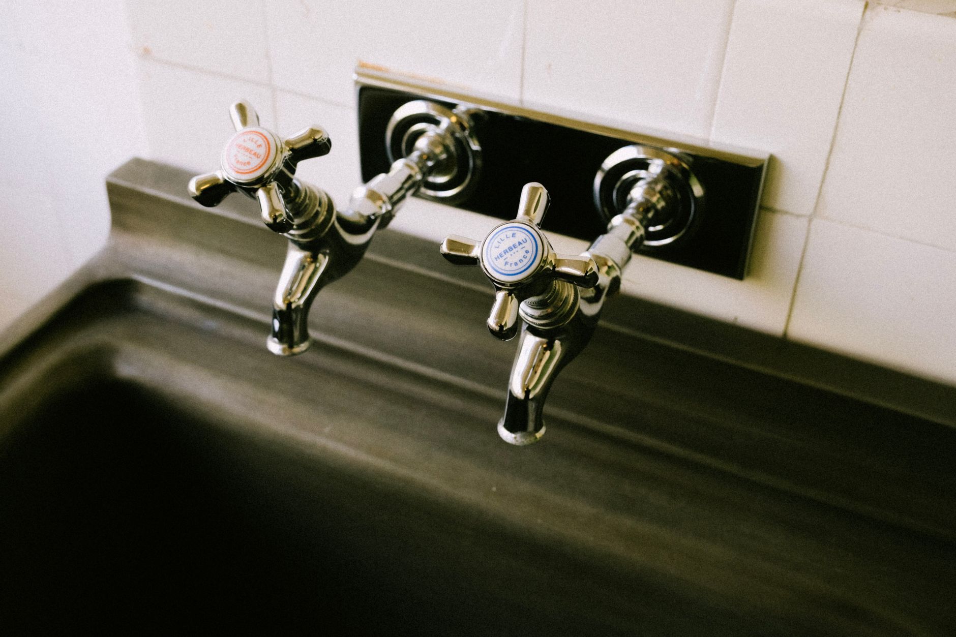 A wall-mounted faucet over a utility sink