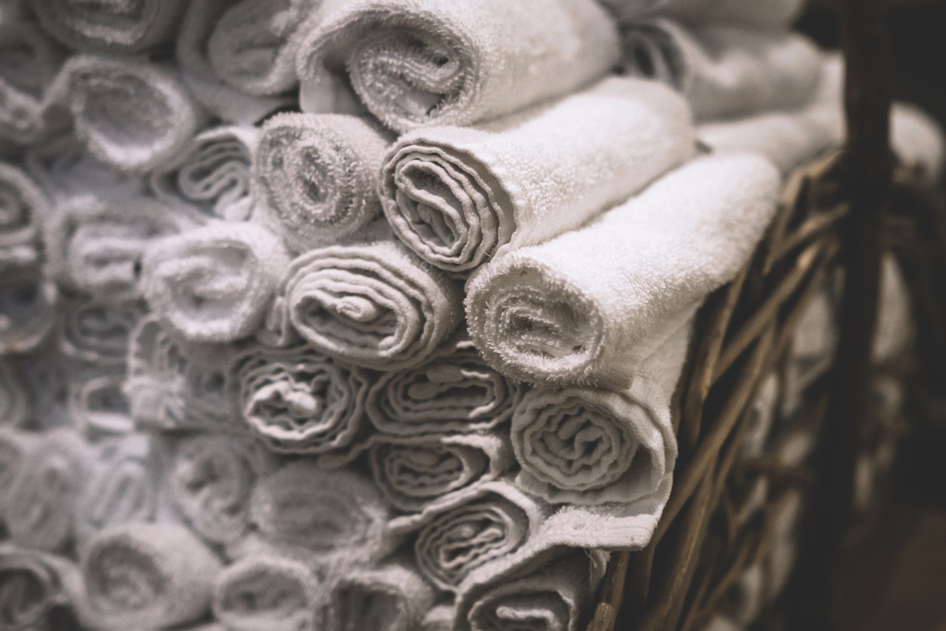 Rolled white towels in a basket