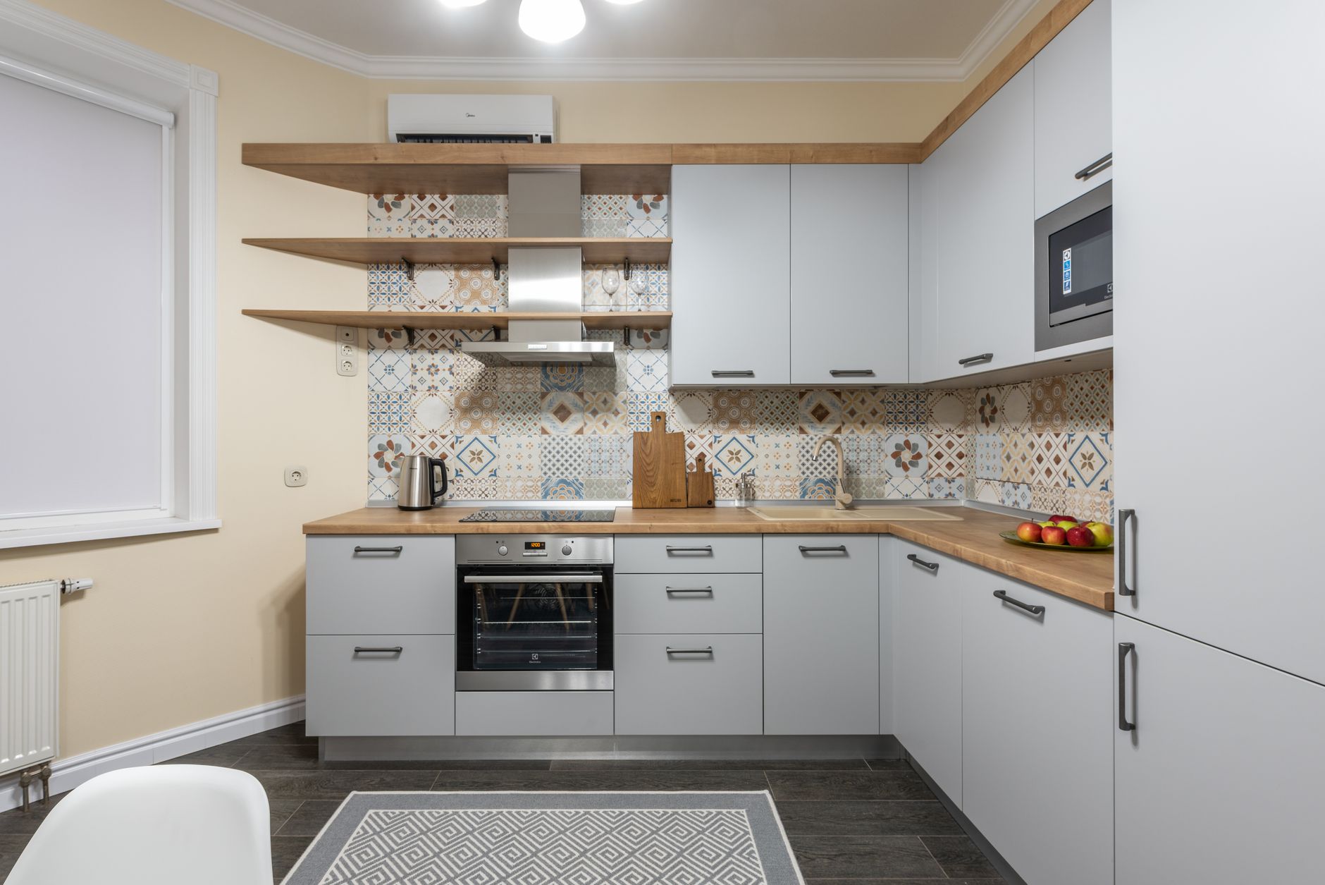 A kitchen with white cabinets and open shelving