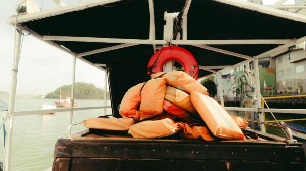 Orange life jackets and a ring buoy stacked on a boat