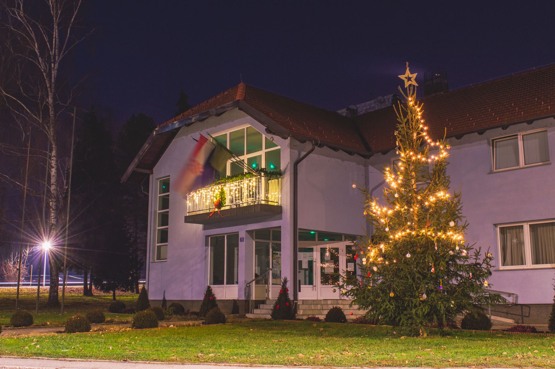 A house with a lit tree out front
