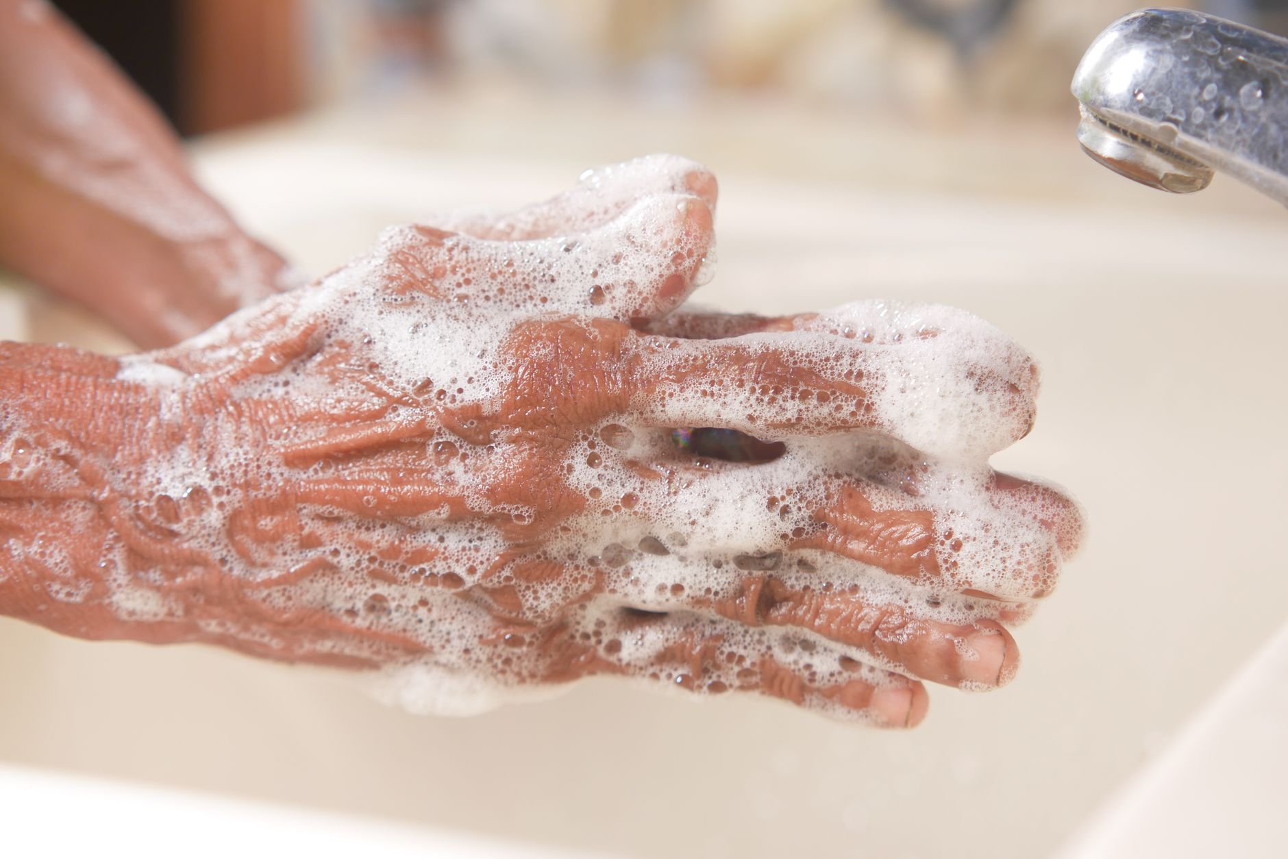 Washing hands with soap at a sink