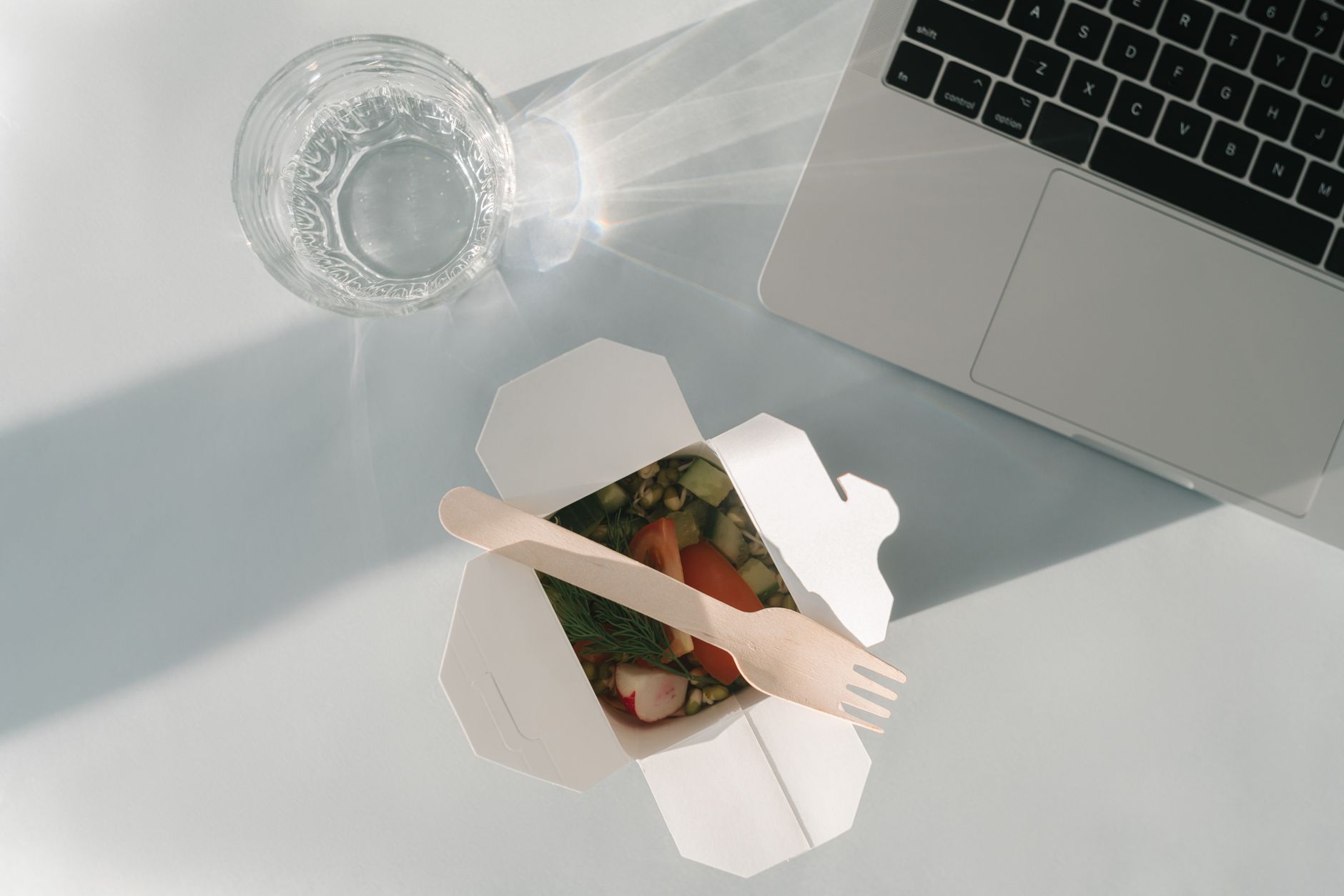 A takeout box beside a laptop