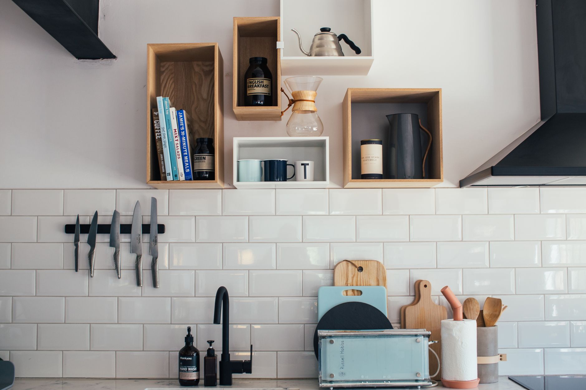 Knives on a magnetic strip above a white tile backsplash