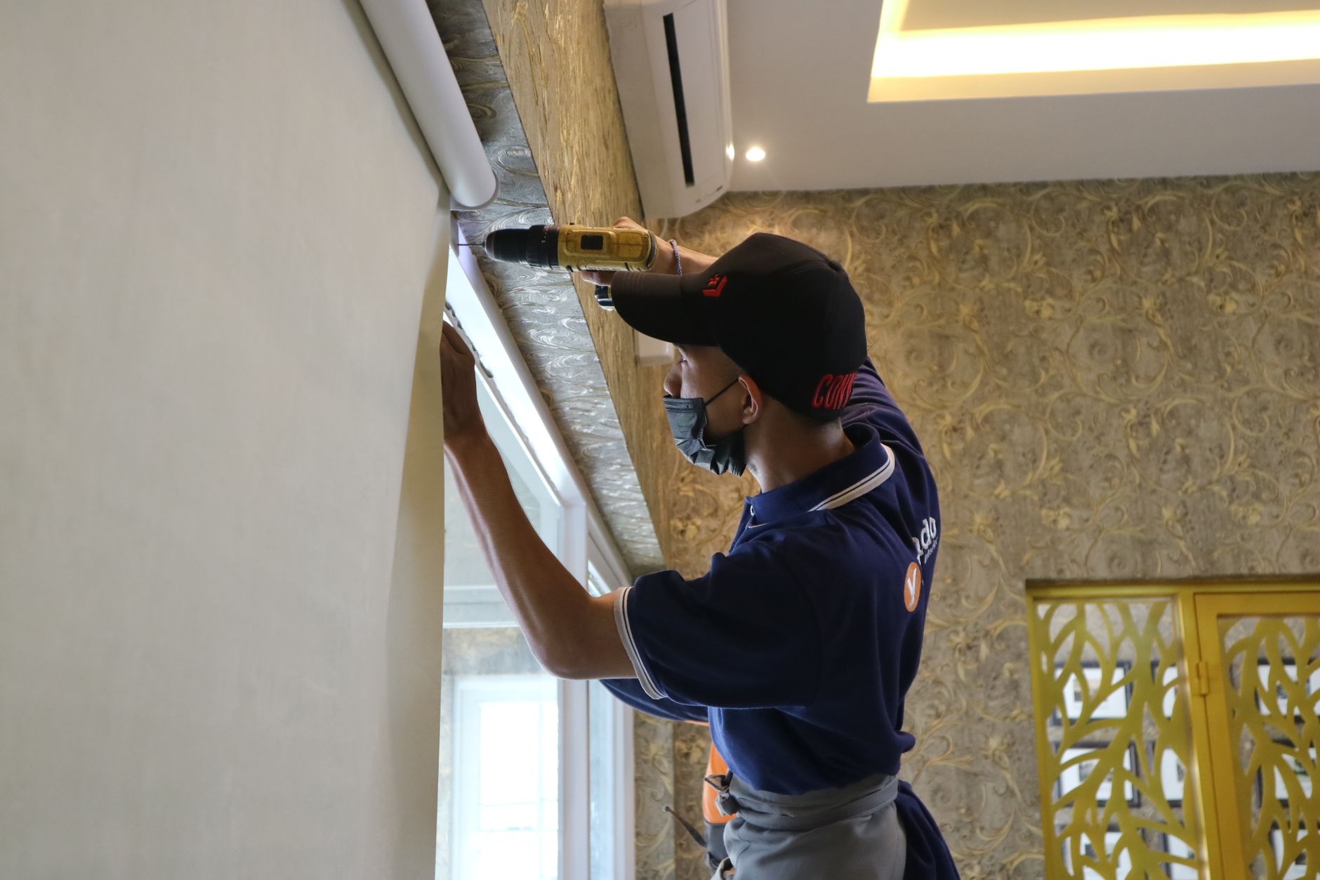 A worker drilling into a wall