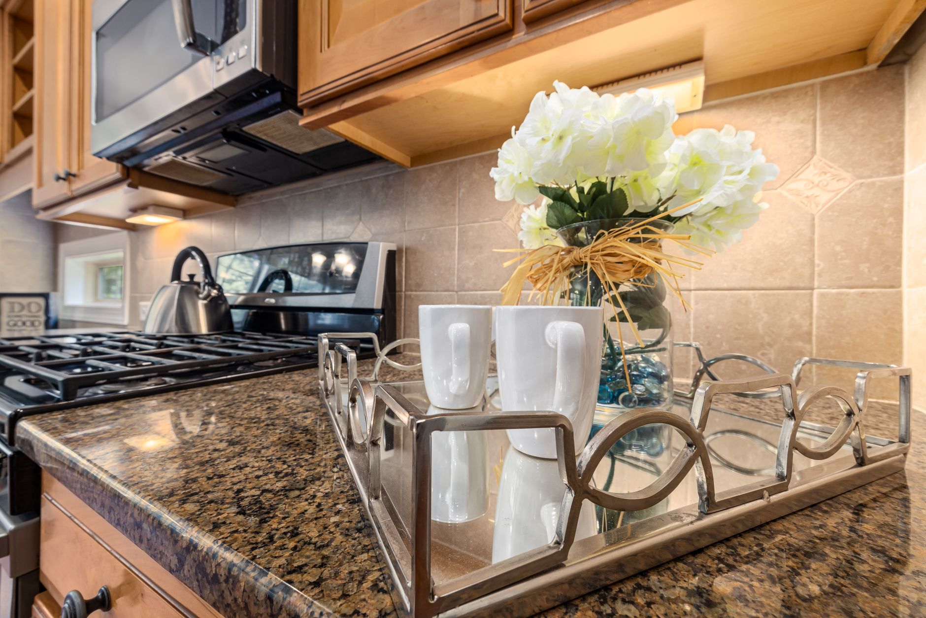 A kitchen counter with a range and microwave