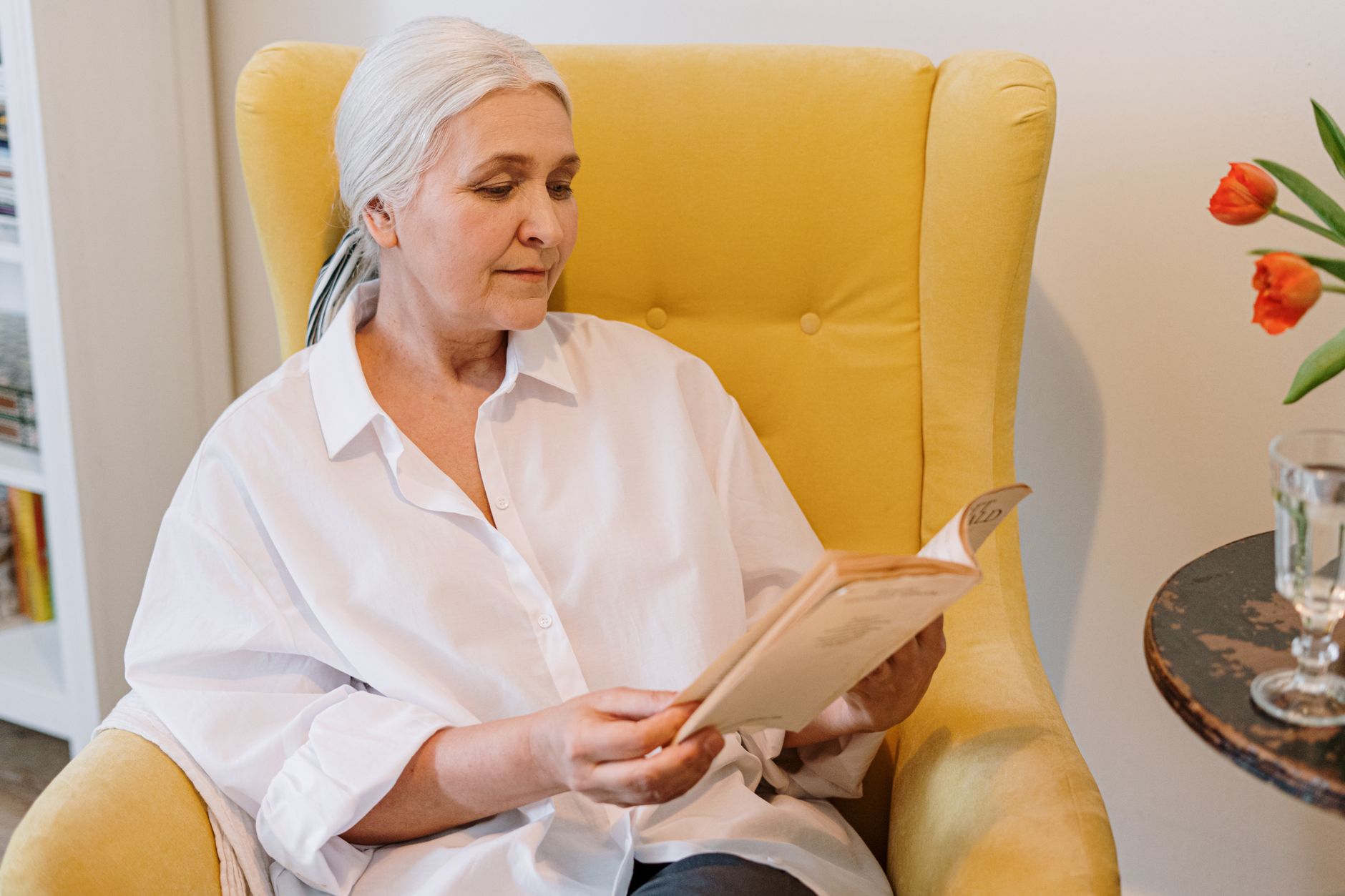 Best magnifying glass with light: an older woman reading in an armchair