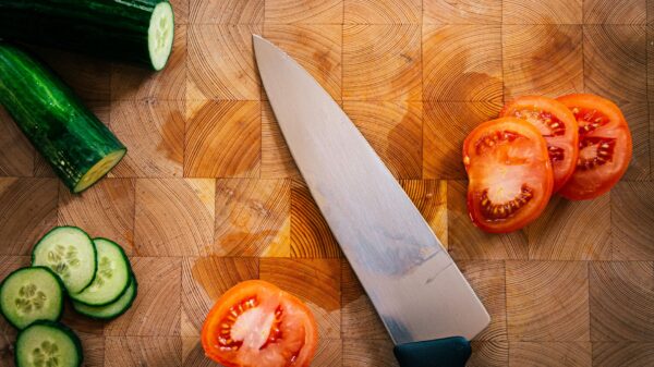 Sliced cucumber and tomato beside a chef knife