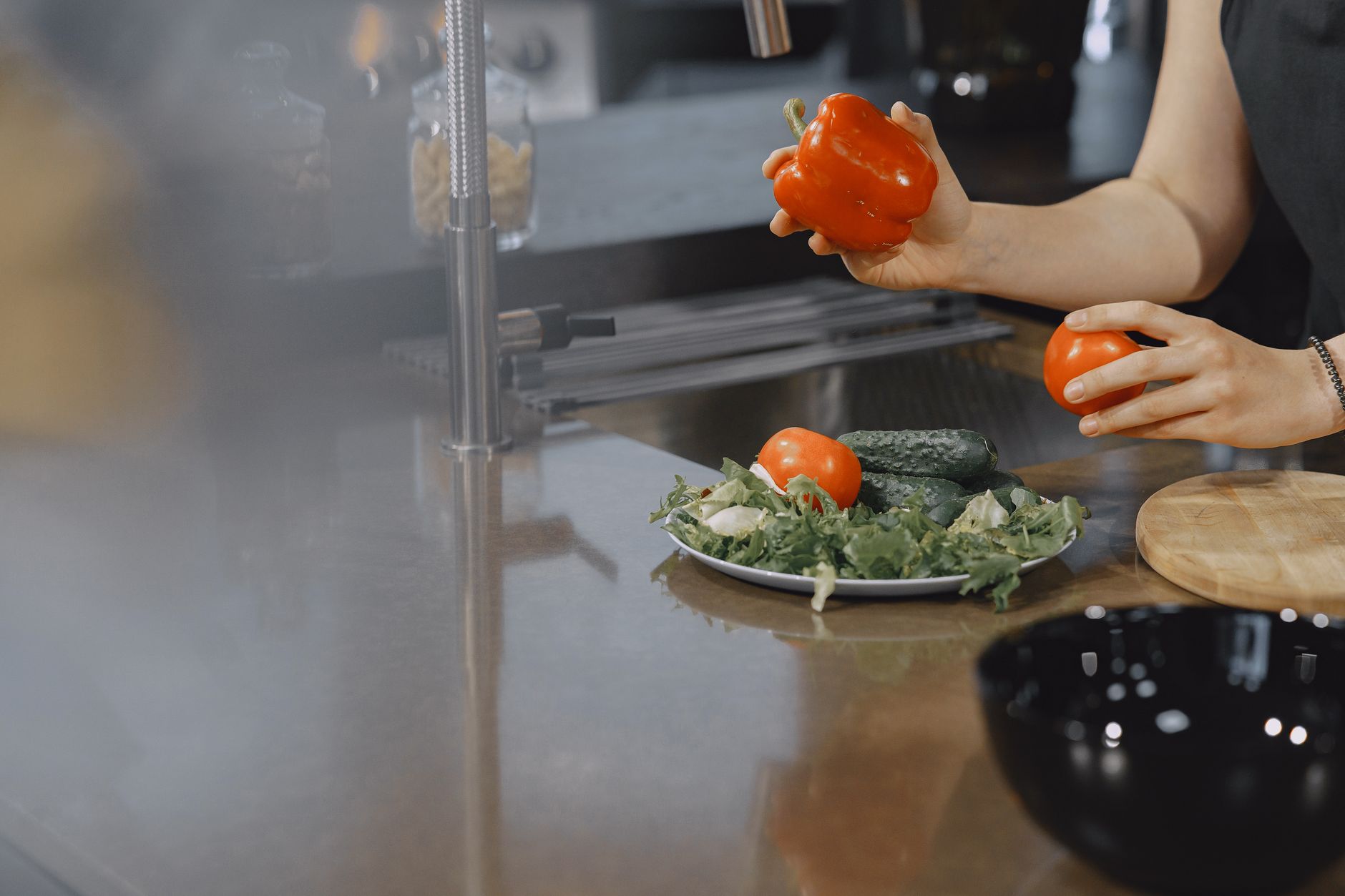 A cook holding a bell pepper over a counter