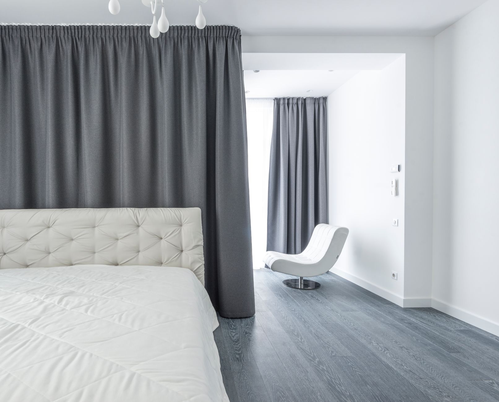 A white bed in a minimalist bedroom