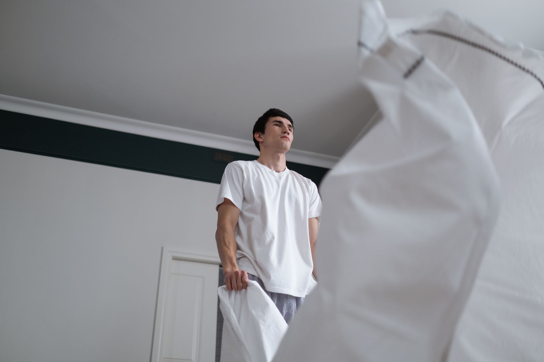 A man shaking out a white sheet