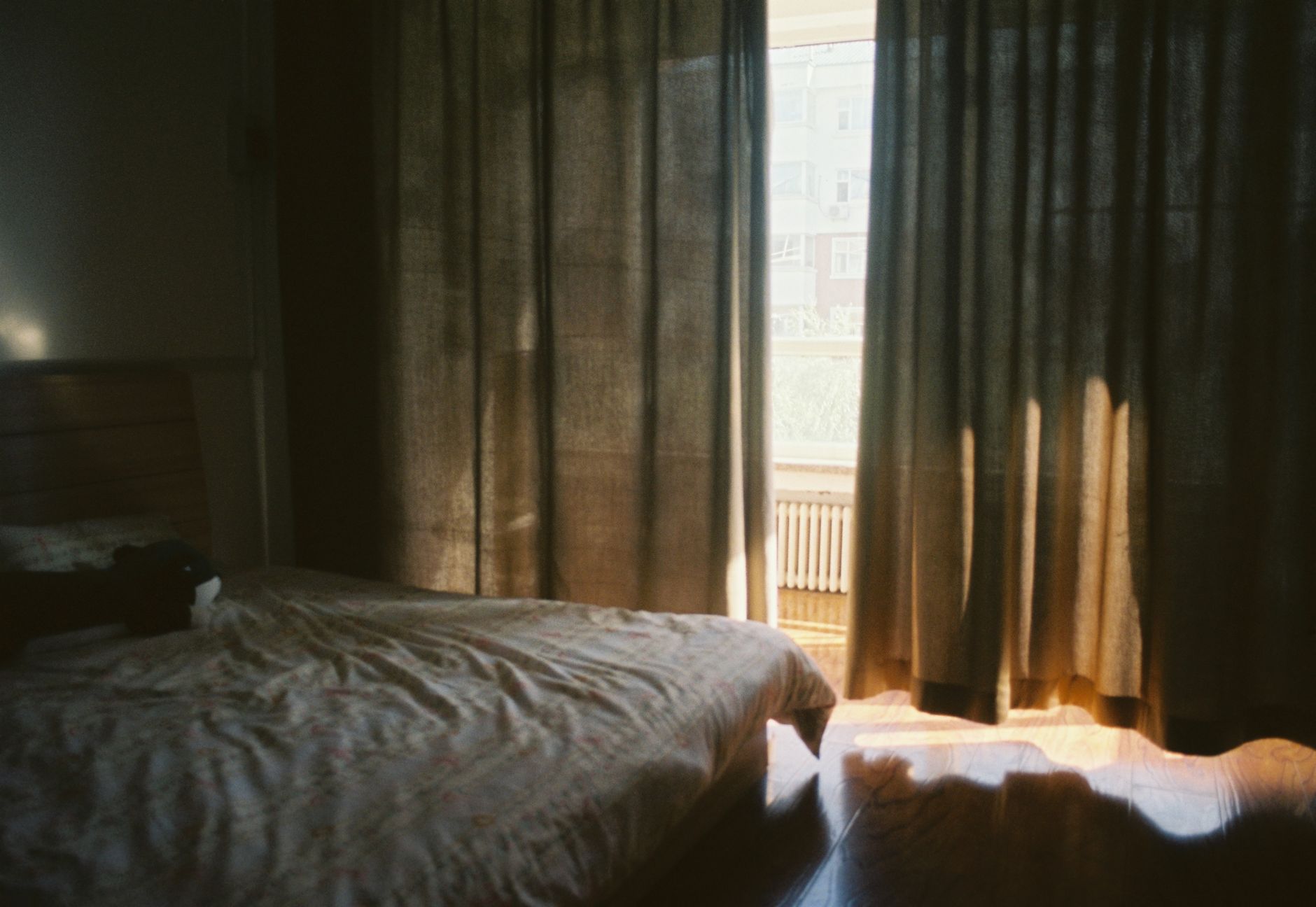 An unmade bed in a dim room