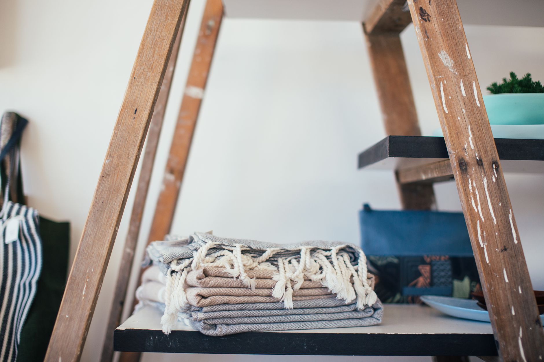 Folded throws on a ladder shelf